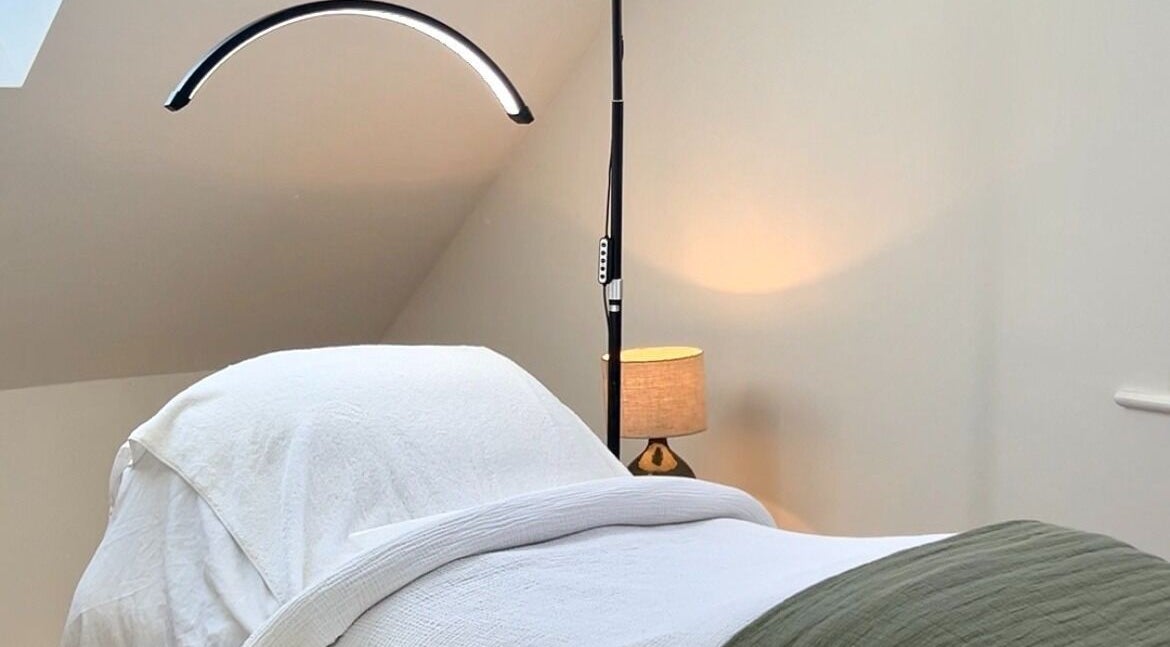 Cozy treatment room at Niamh Trevor Skin in Hampstead Norreys, England, GB featuring a neatly made bed and ambient lighting.