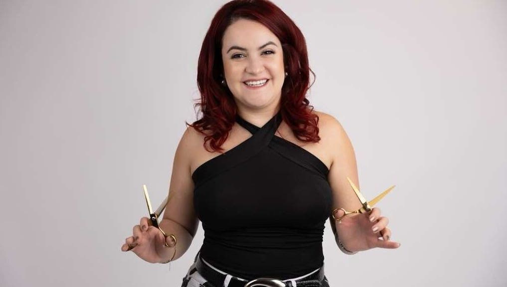 Hair stylist at Pearlie Things holding scissors, Phoenix, Arizona, US.