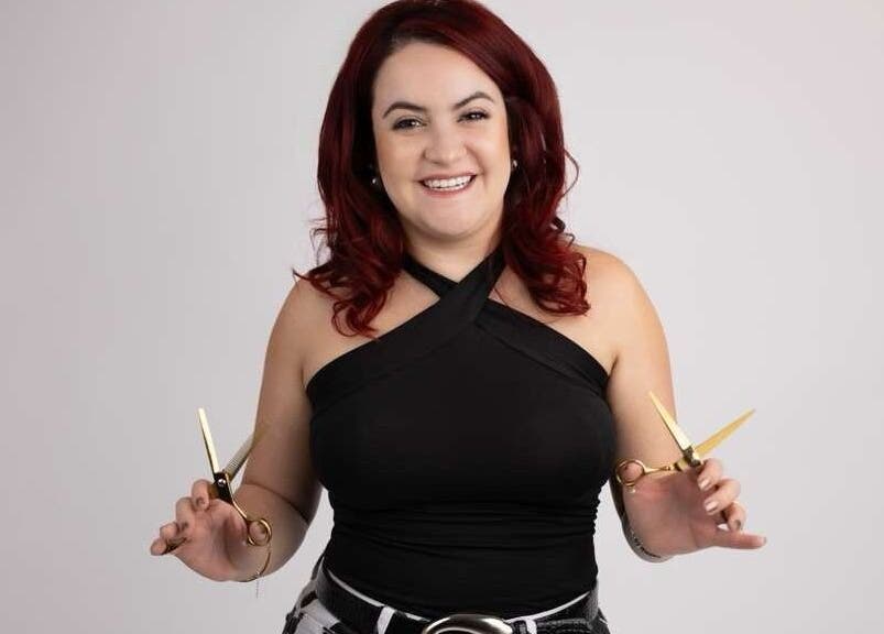 Hair stylist at Pearlie Things holding scissors, Phoenix, Arizona, US.