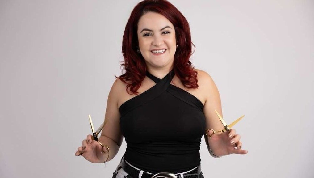 Hair stylist at Pearlie Things holding scissors, Phoenix, Arizona, US. Expert in beauty services.