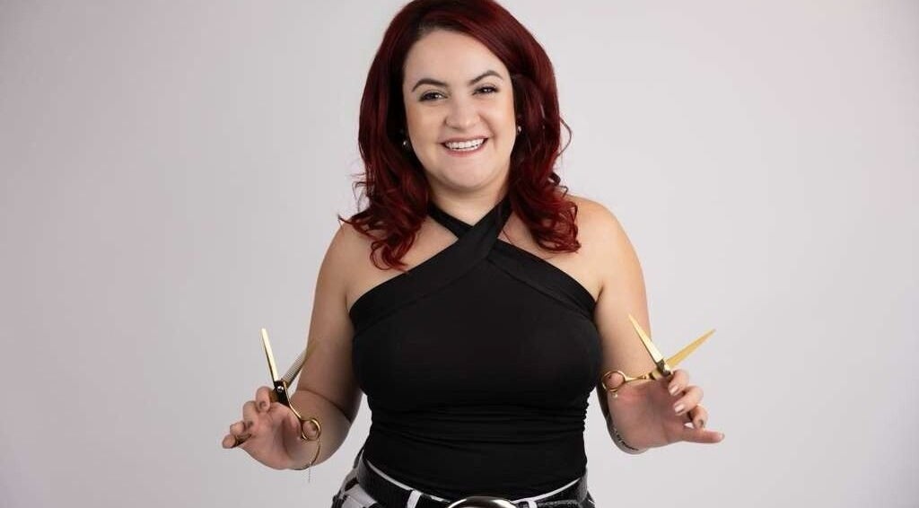 Hair stylist at Pearlie Things holding scissors, Phoenix, Arizona, US. Expert in beauty services.