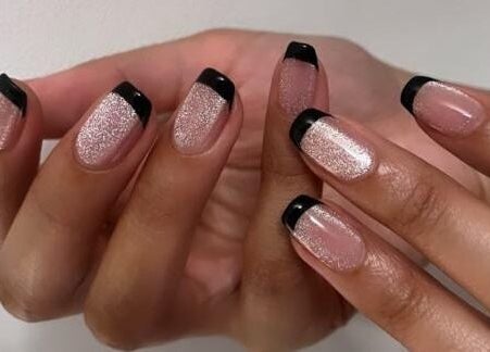 Glossy black French tips on glitter nails at Nai Spa, Riyadh, Riyadh Province, SA. Perfect for a chic look.