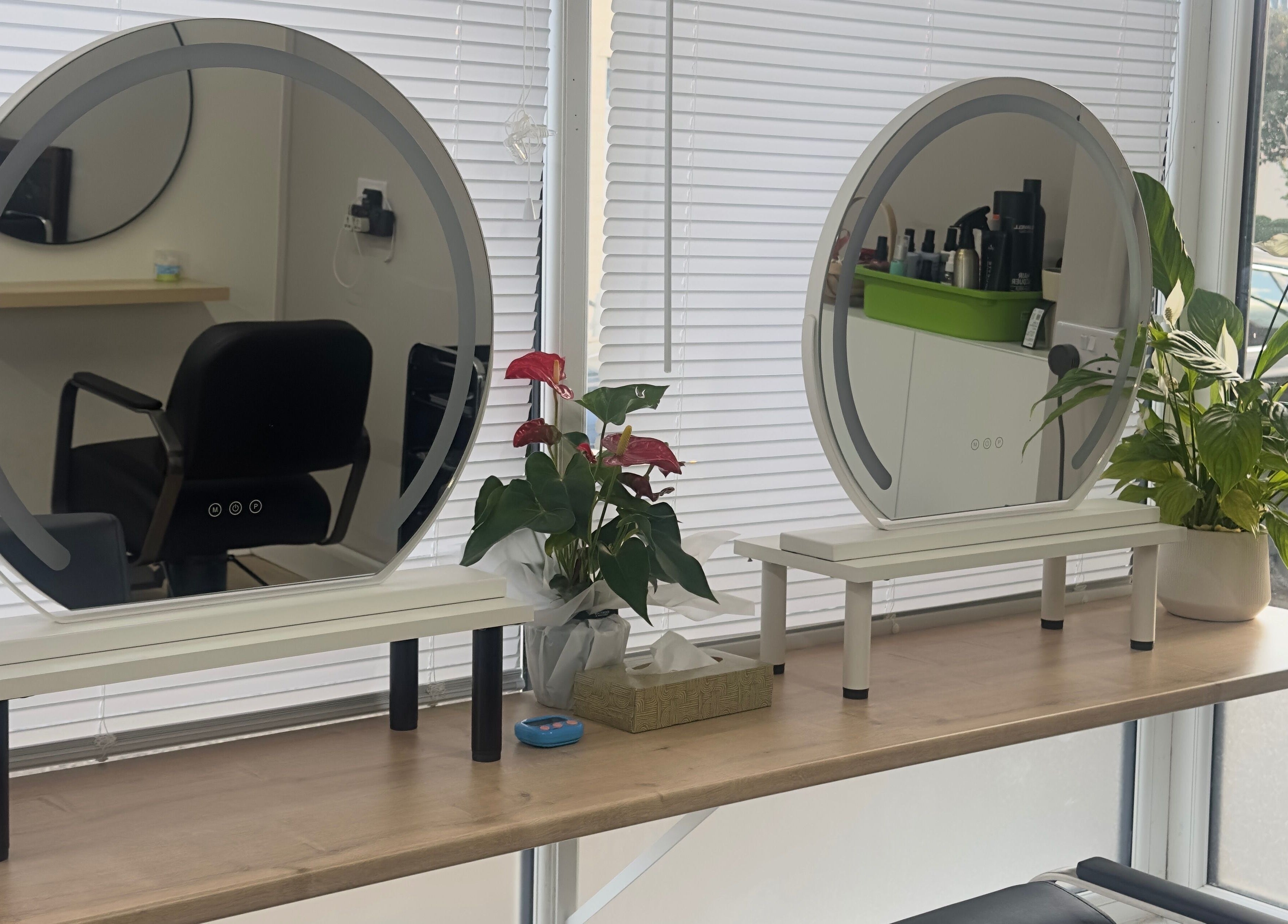Modern styling stations at 真Jin Salon, Warrington, England, showcasing sleek mirrors and lush plants.