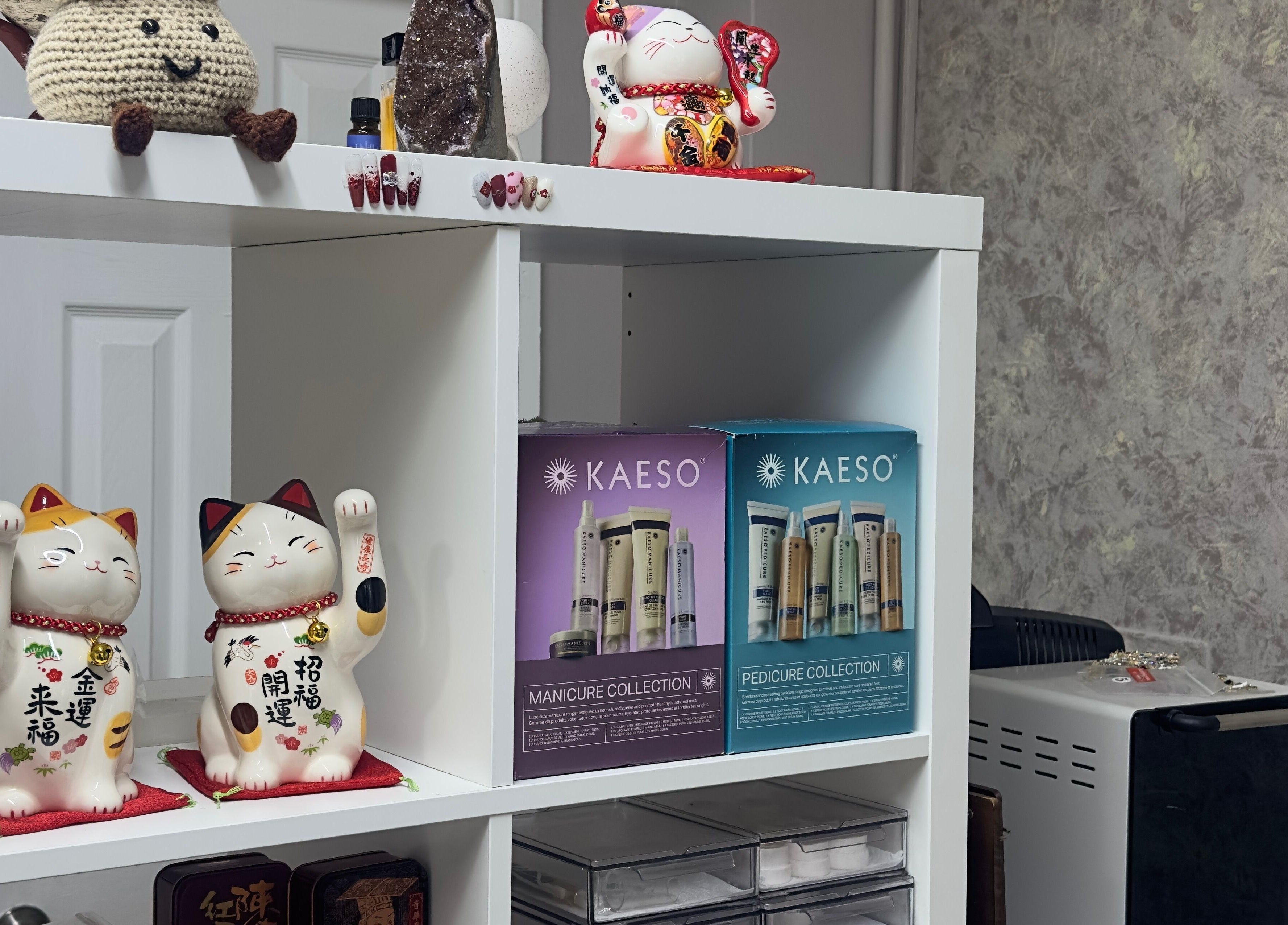 Decorative shelf with lucky cats and Kaeso products at 真Jin Salon, Warrington, England, GB.