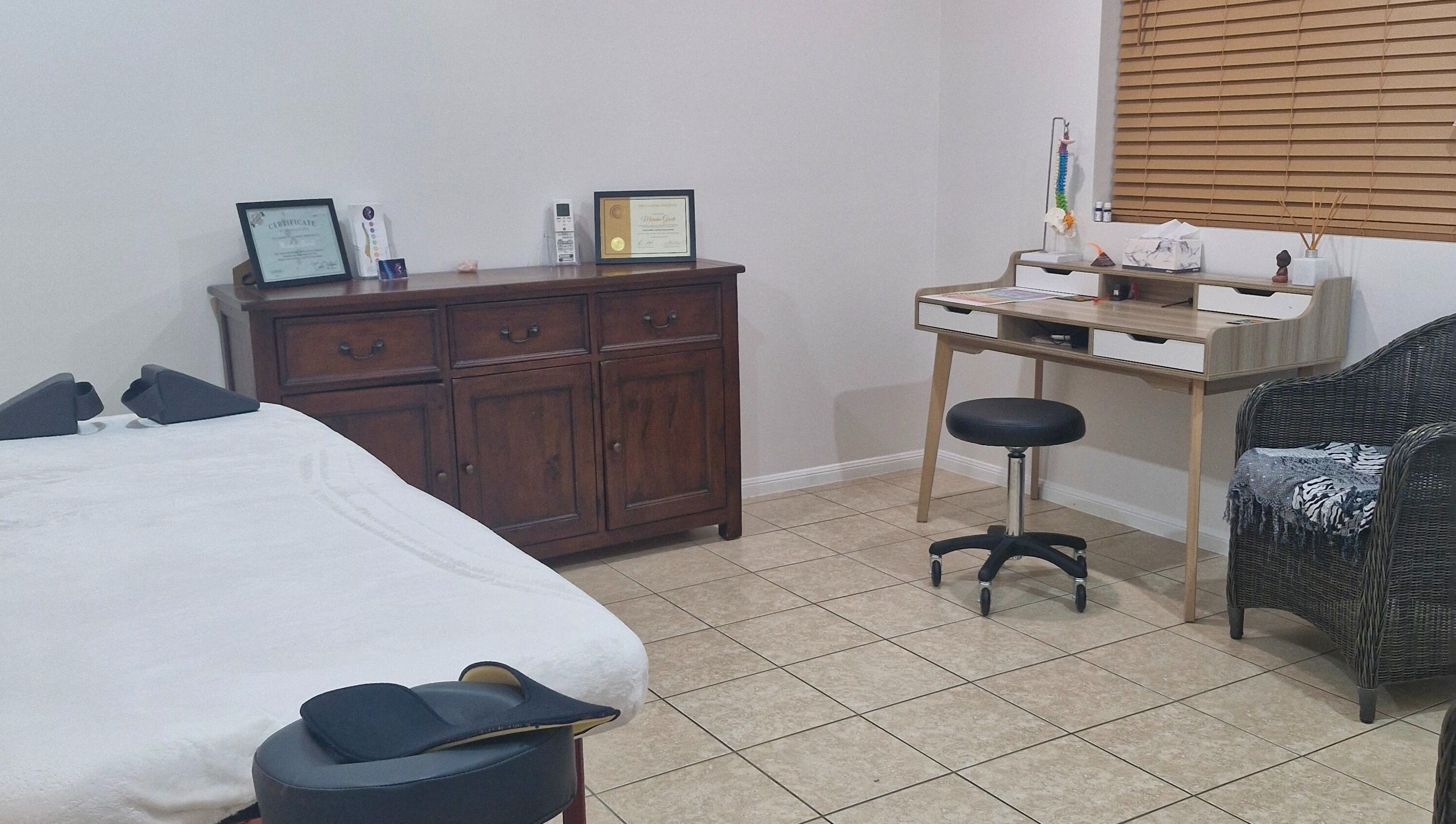 Cozy therapy room at Southside Spinal Flow in Cairns, Queensland, AU with massage table and wooden furniture.