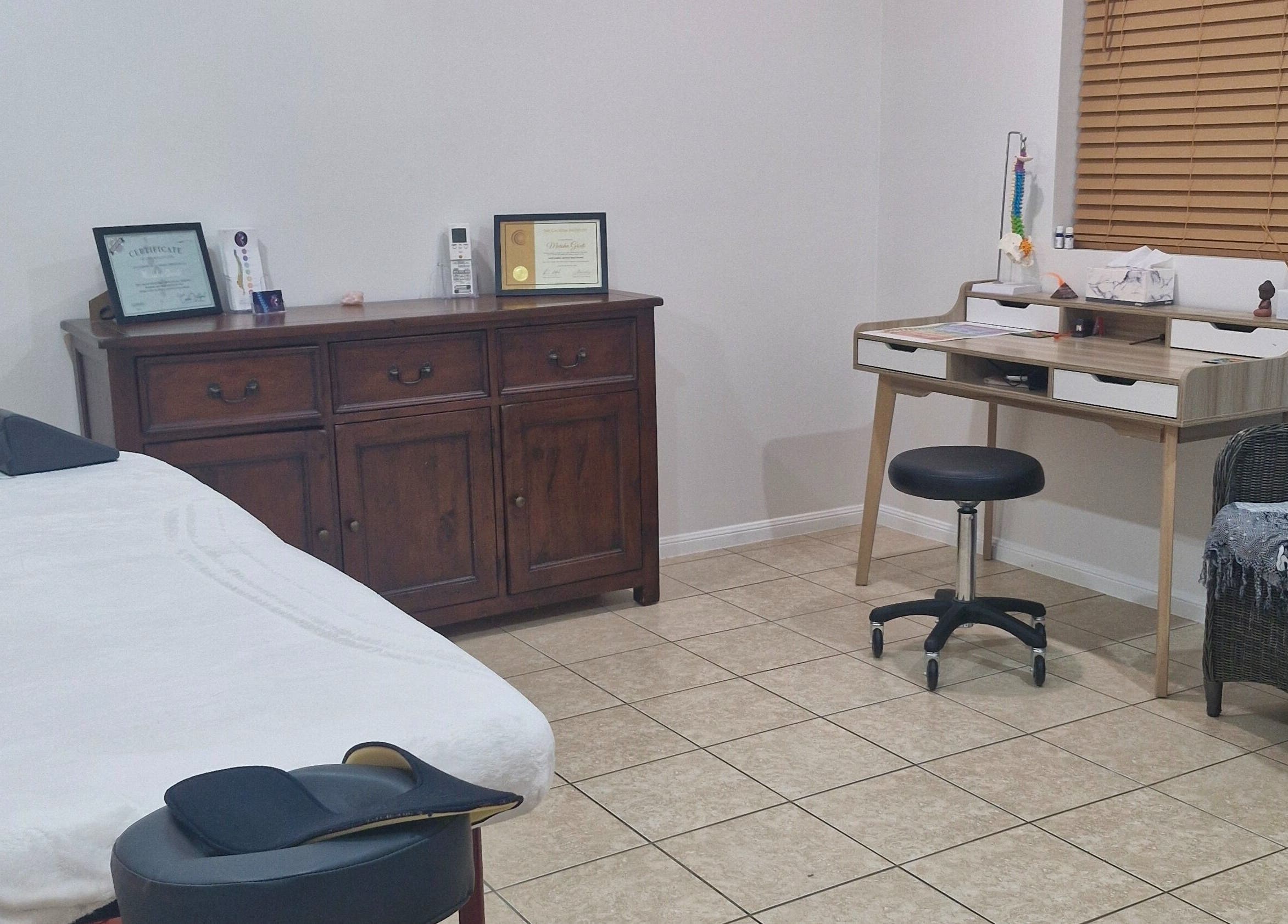 Cozy therapy room at Southside Spinal Flow in Cairns, Queensland, AU with massage table and wooden furniture.
