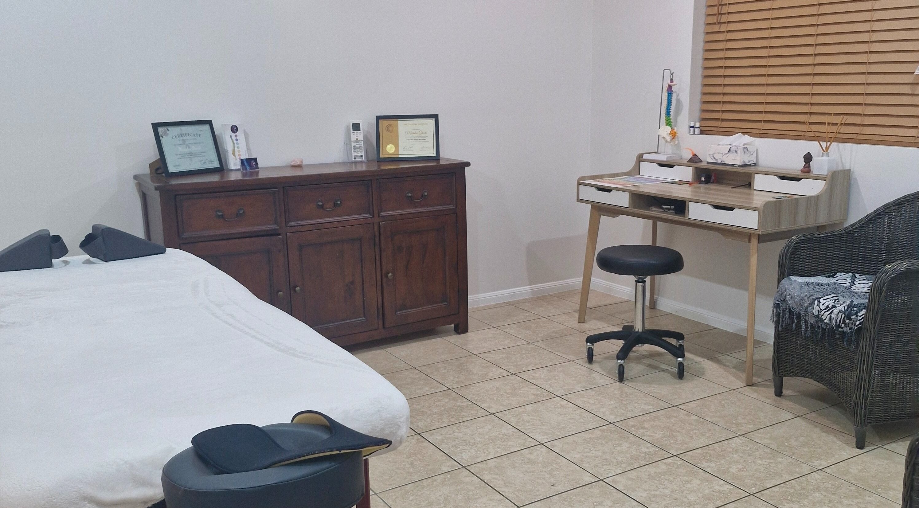 Cozy therapy room at Southside Spinal Flow in Cairns, Queensland, AU with massage table and wooden furniture.