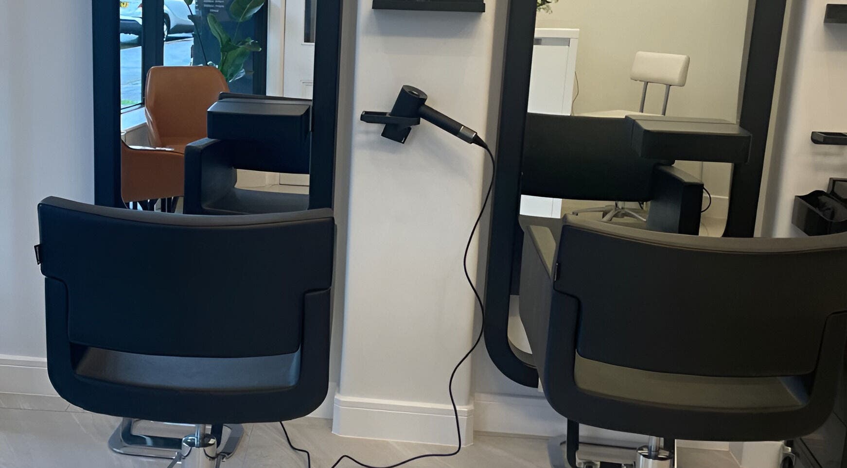 Modern salon chairs and mirrors at Unihair, stylish hair styling space in London, England, GB.