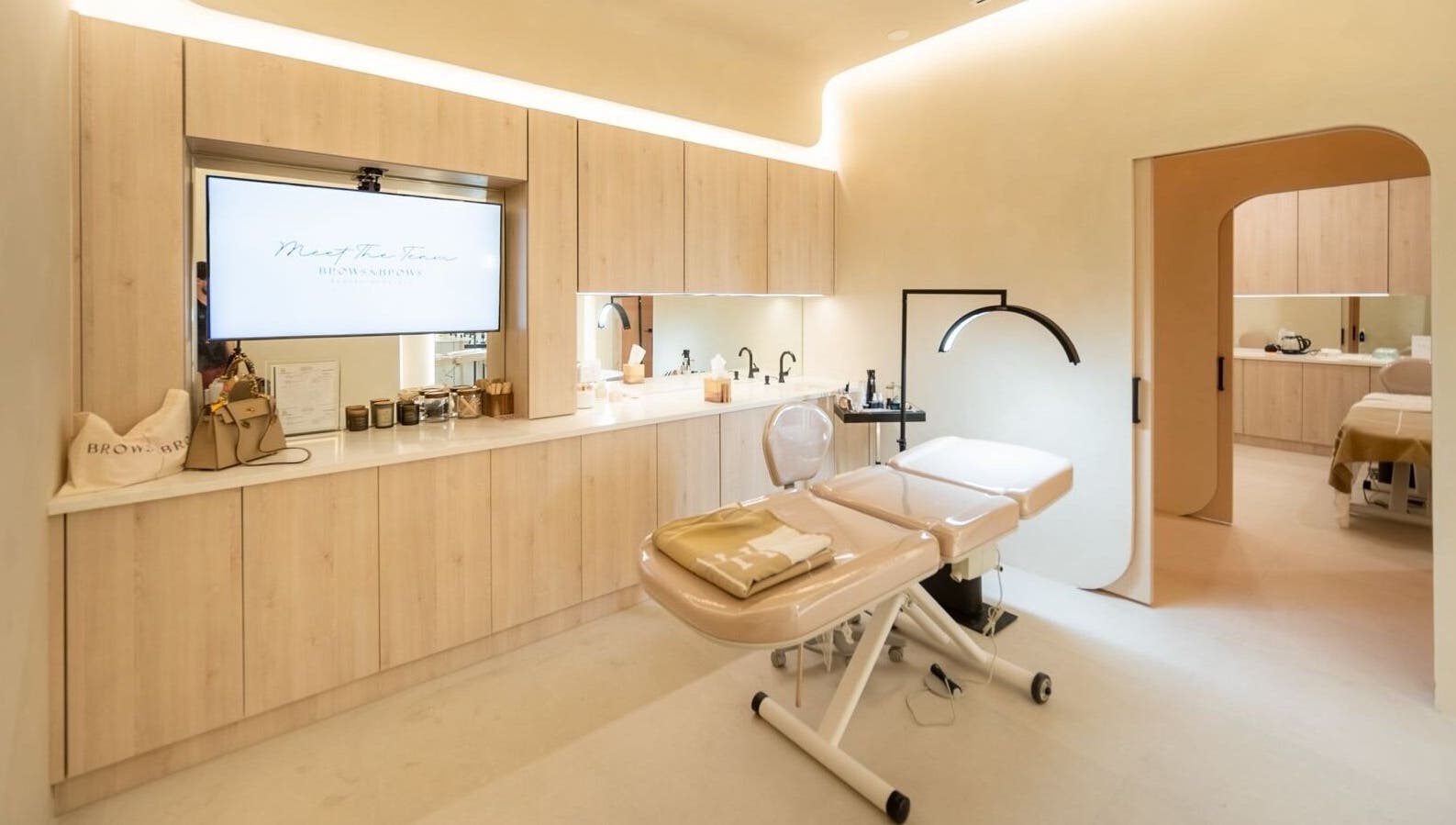 Modern spa room at Brows and Brows, Hallandale Beach, Florida, US, featuring a massage table and sleek decor.