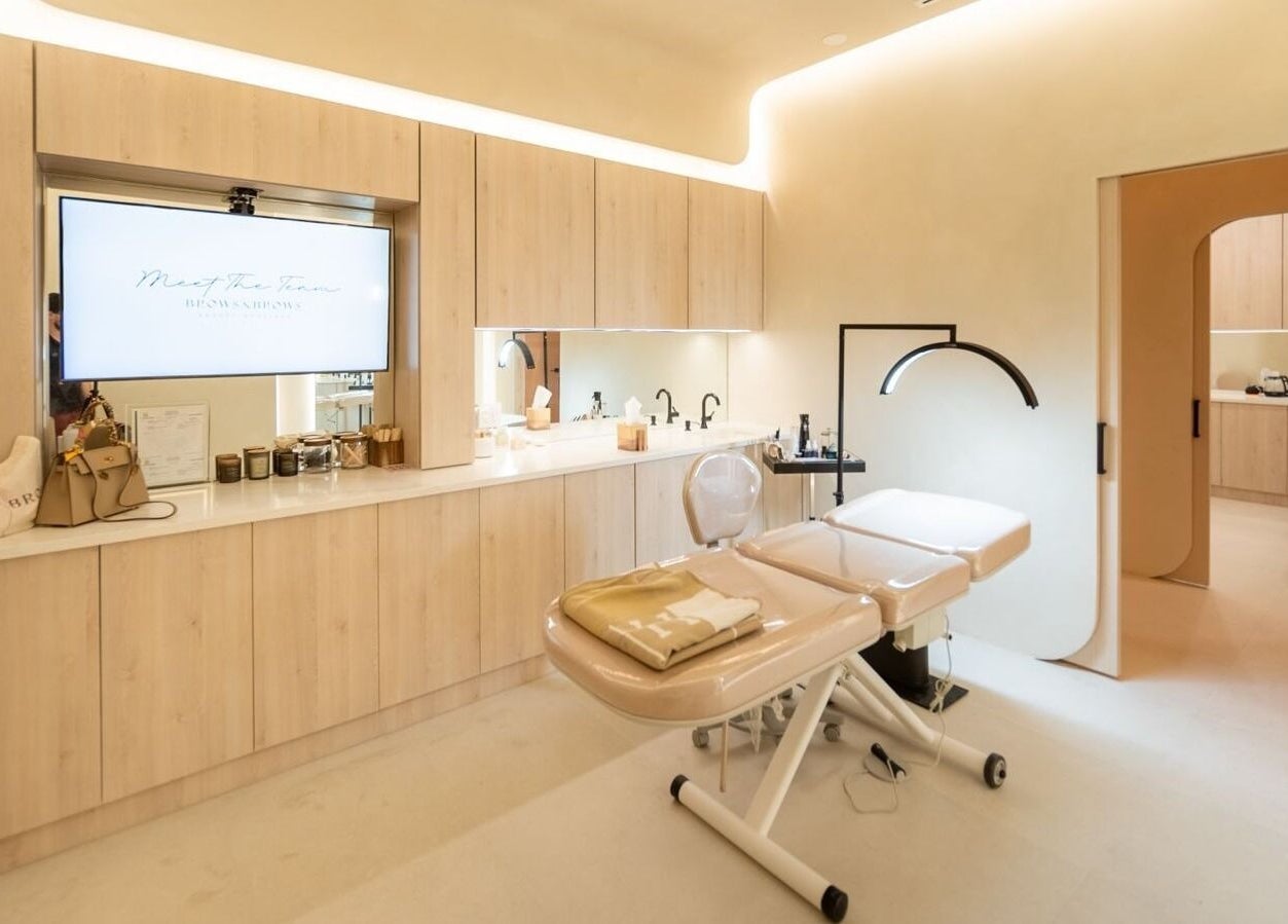 Modern spa room at Brows and Brows, Hallandale Beach, Florida, US, featuring a massage table and sleek decor.