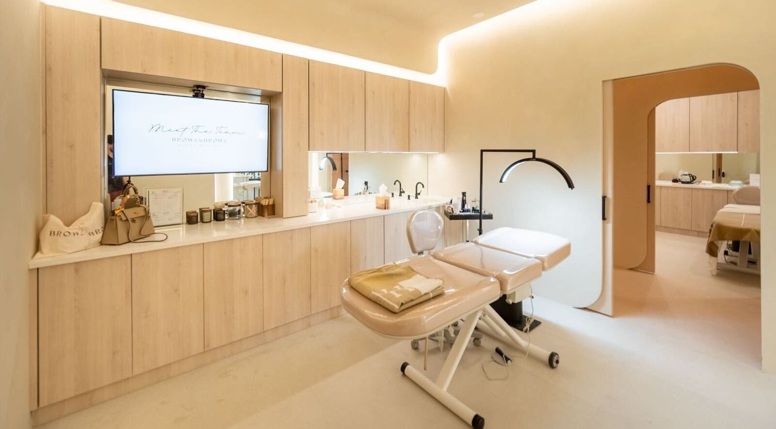 Modern spa room at Brows and Brows, Hallandale Beach, Florida, US, featuring a massage table and sleek decor.