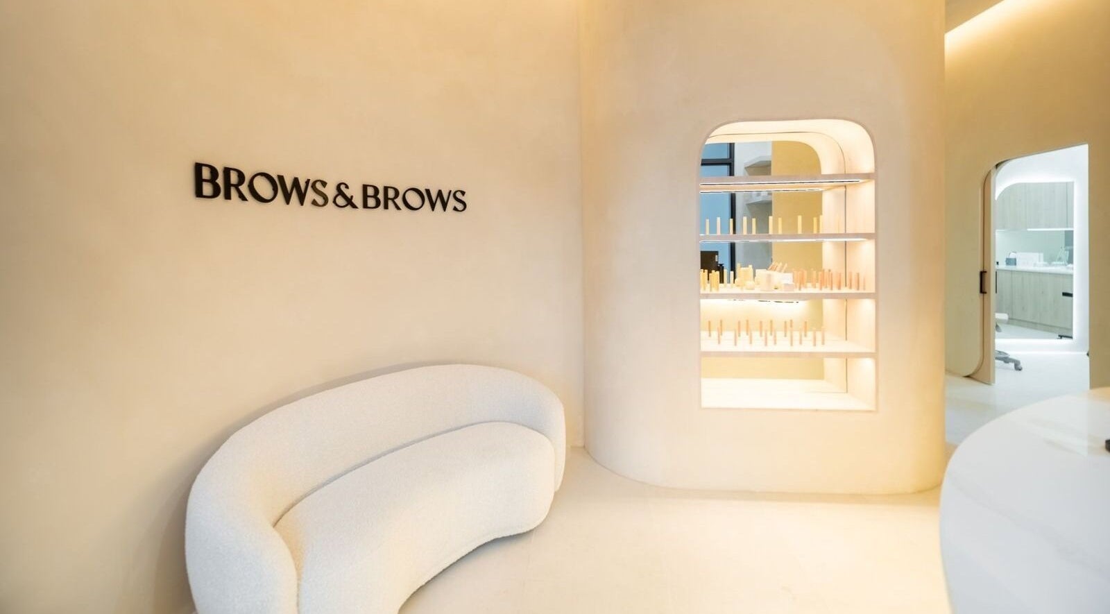 Chic interior at Brows and Brows in Hallandale Beach, Florida, US with elegant sofa and product display.