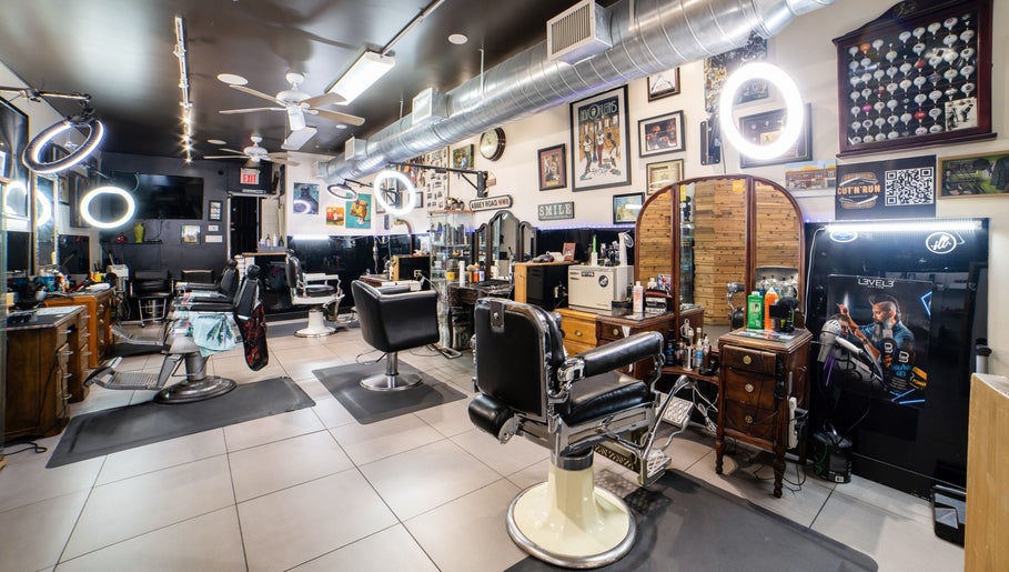 Elegant interior of Cut N Run Barbershop in Toronto, Ontario, CA showcasing sleek barber chairs and wall art.