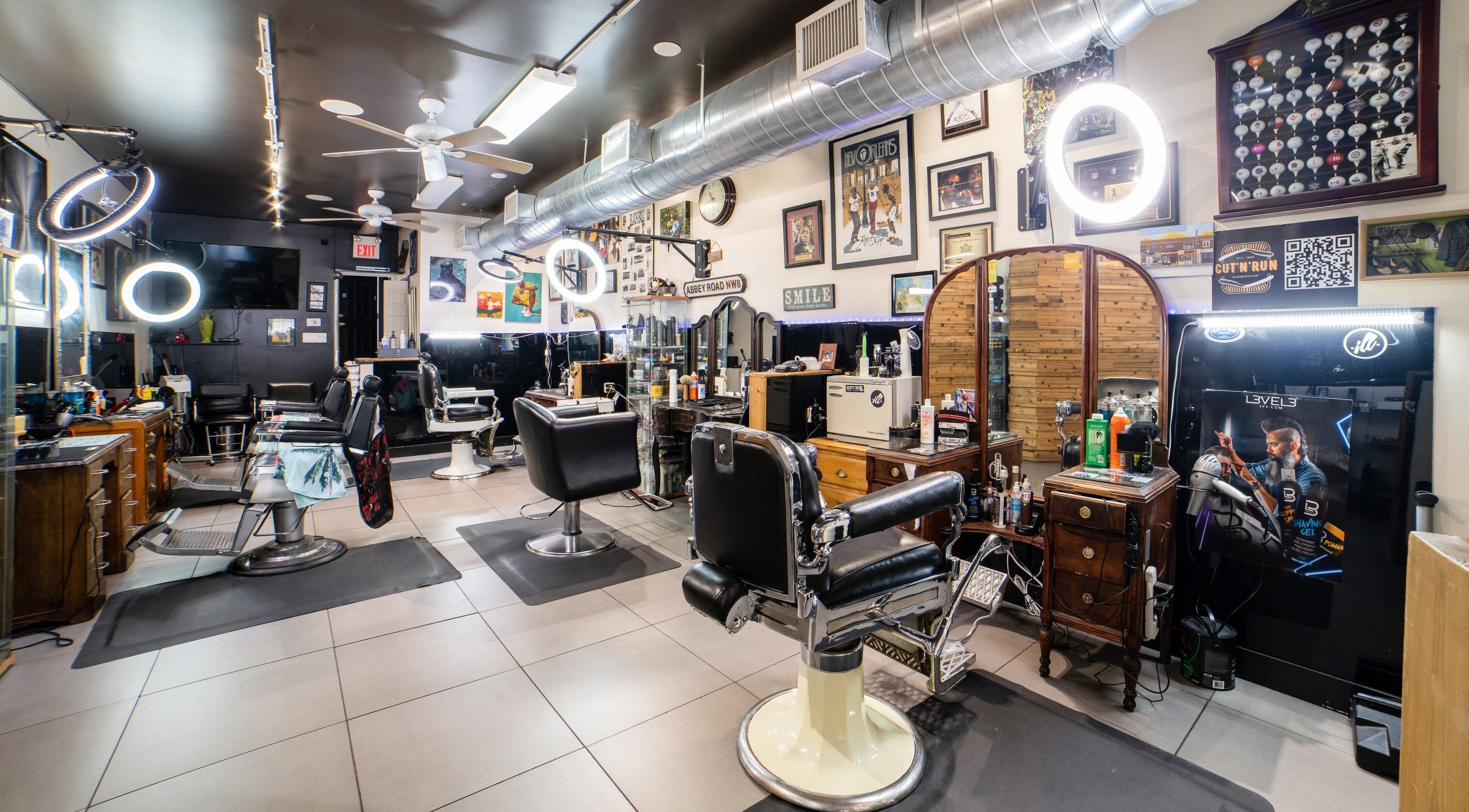 Elegant interior of Cut N Run Barbershop in Toronto, Ontario, CA showcasing sleek barber chairs and wall art.