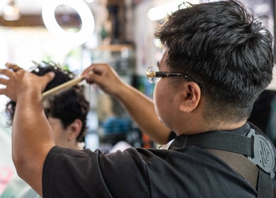 Professional barber styling hair at Cut N Run Barbershop, Toronto, Ontario, CA.