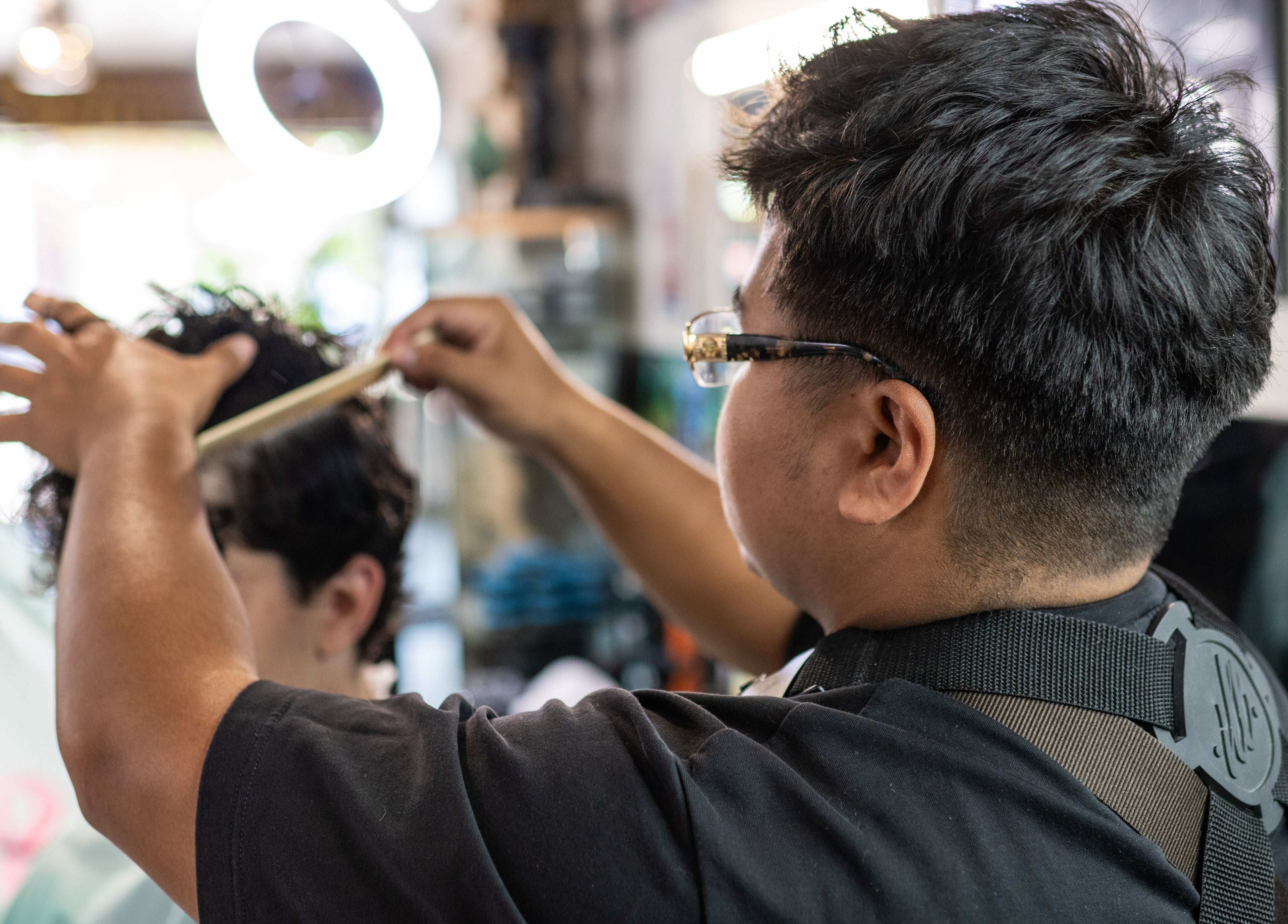 Professional barber styling hair at Cut N Run Barbershop, Toronto, Ontario, CA.