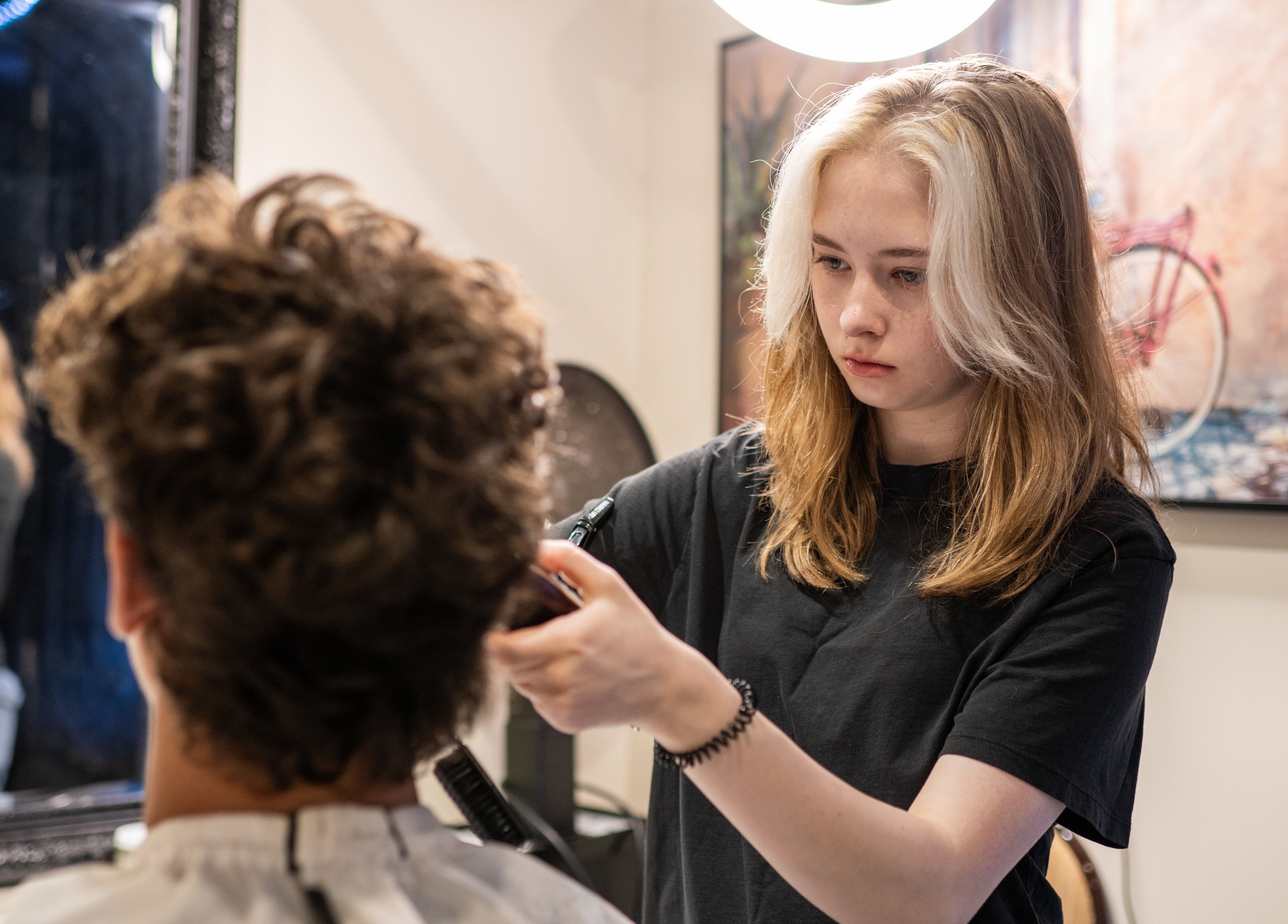Stylist at Cut N Run Barbershop in Toronto, Ontario, CA expertly cutting customer's hair.