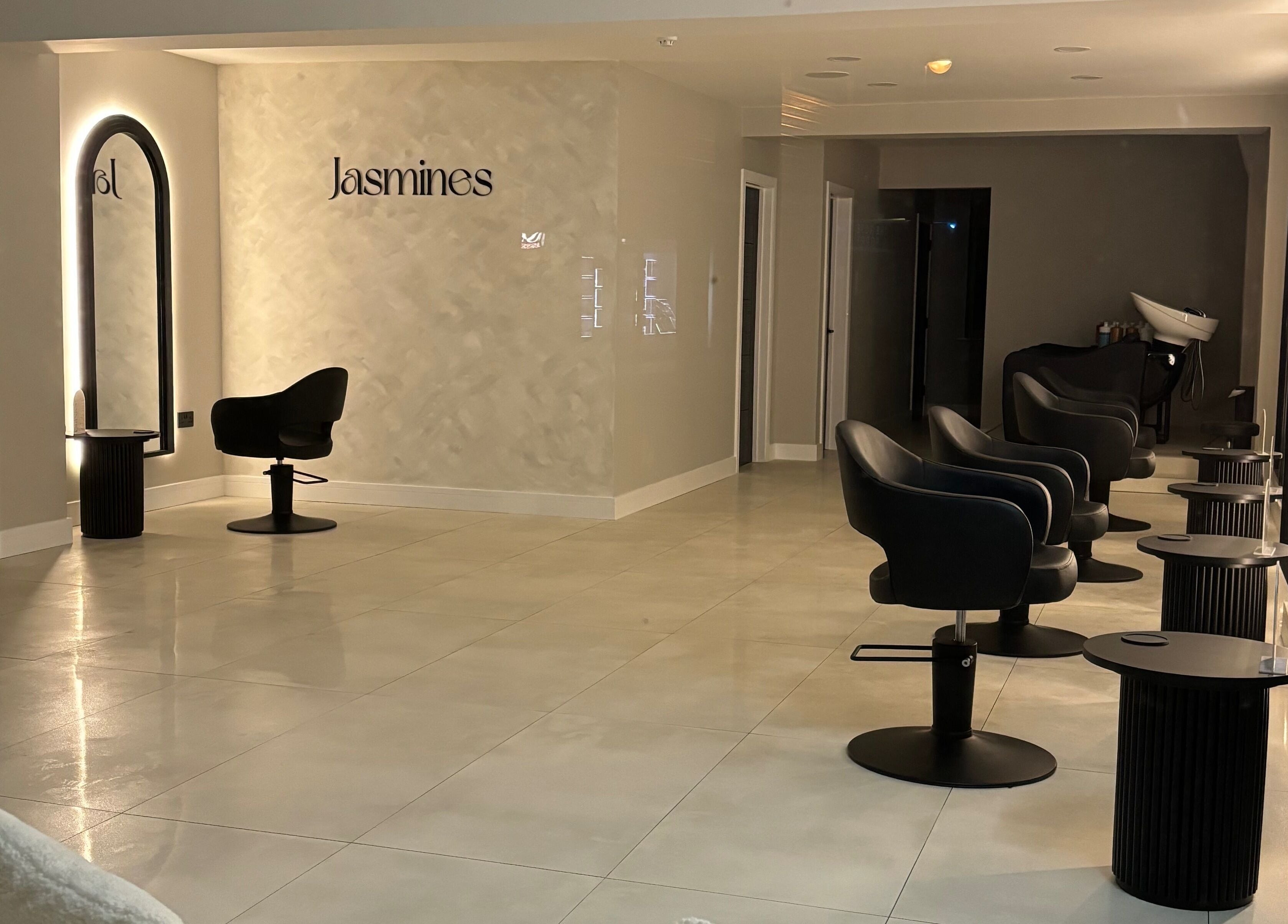 Elegant interior of Jasmines salon in Fareham, England, GB with sleek black chairs and modern lighting.