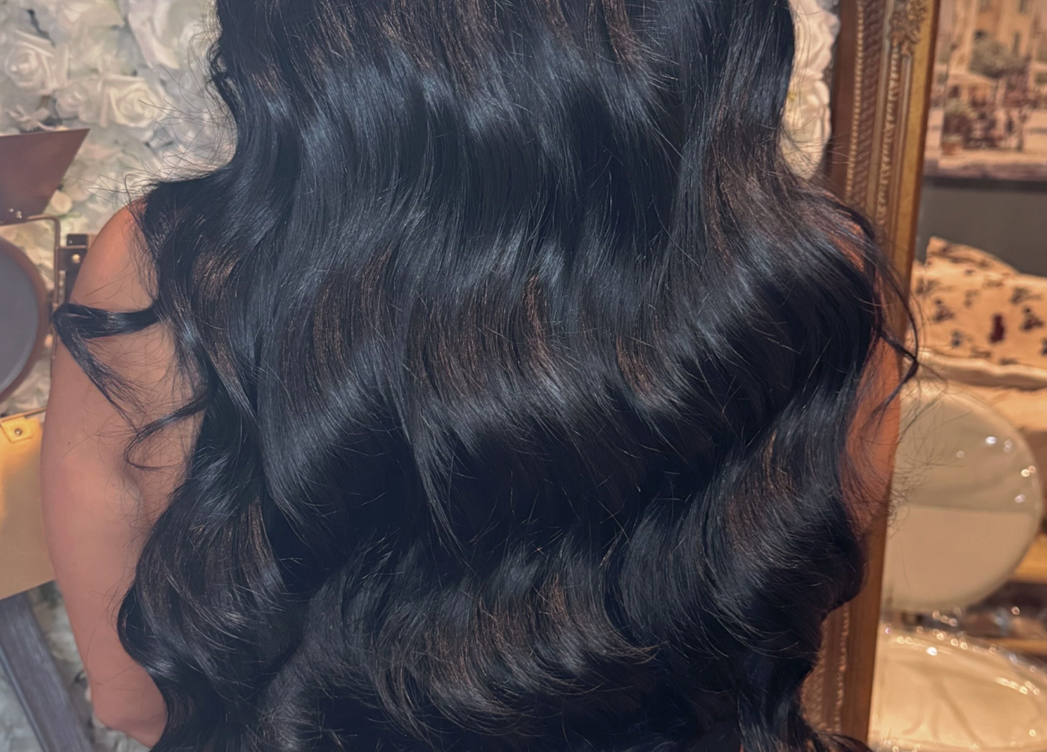 Long, black wavy hair styled at Hair Extensions by Kinga Liu, Leeds, England, GB, in an elegant salon setting.