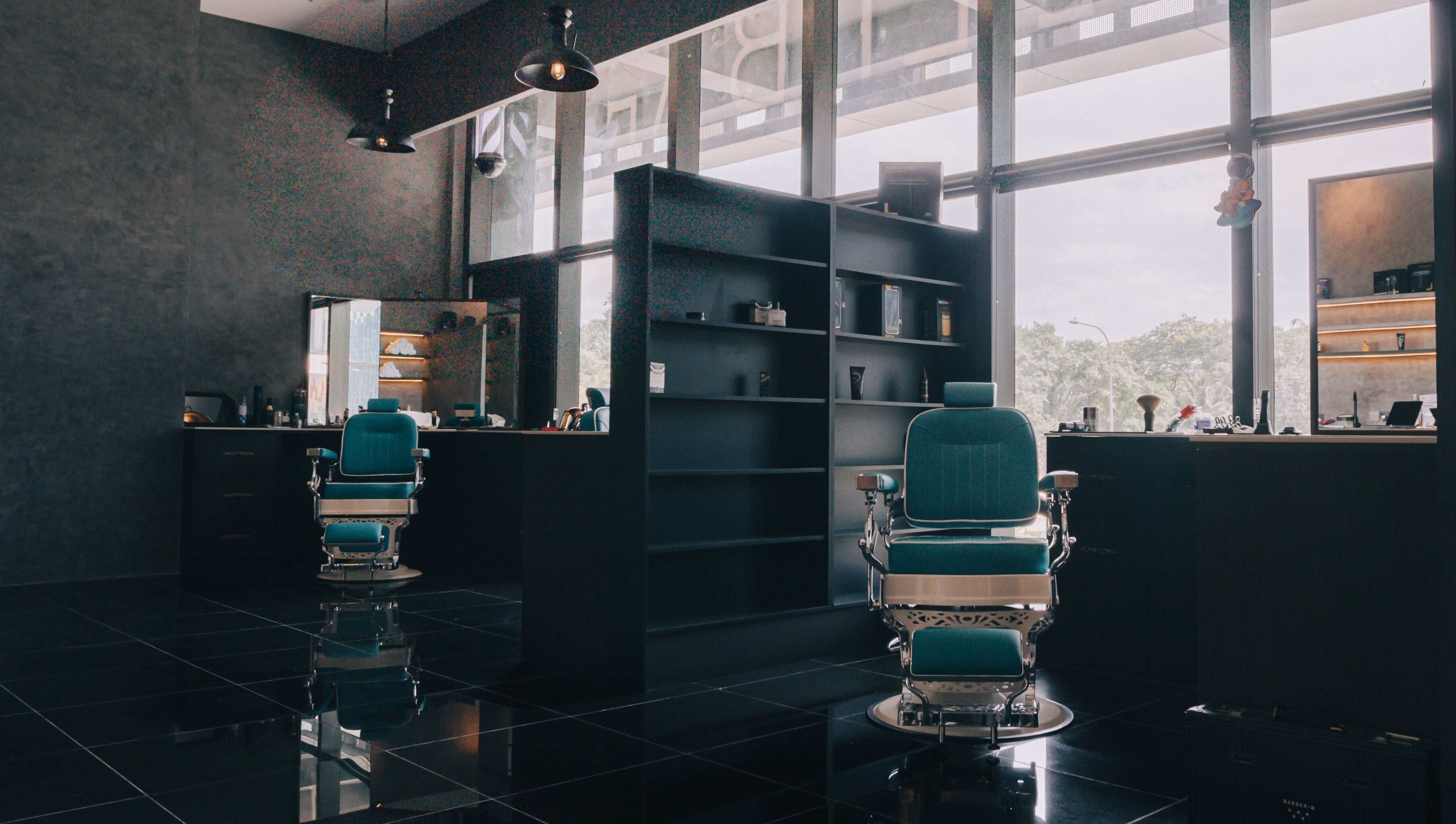 Barber chairs at BarberBar, Pavilion Embassy, Kuala Lumpur. Modern interior setting with large windows.