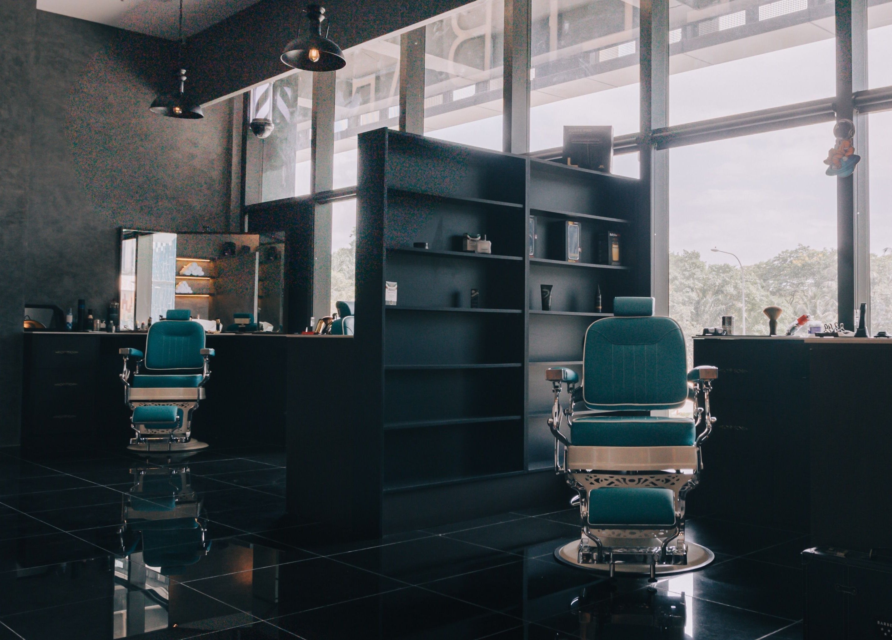 Barber chairs at BarberBar, Pavilion Embassy, Kuala Lumpur. Modern interior setting with large windows.