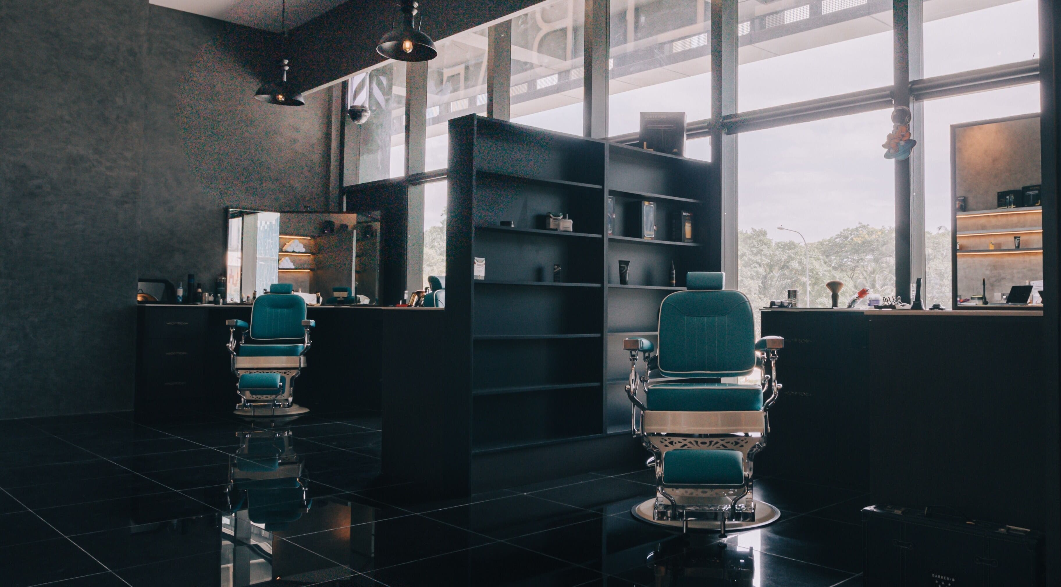 Barber chairs at BarberBar, Pavilion Embassy, Kuala Lumpur. Modern interior setting with large windows.