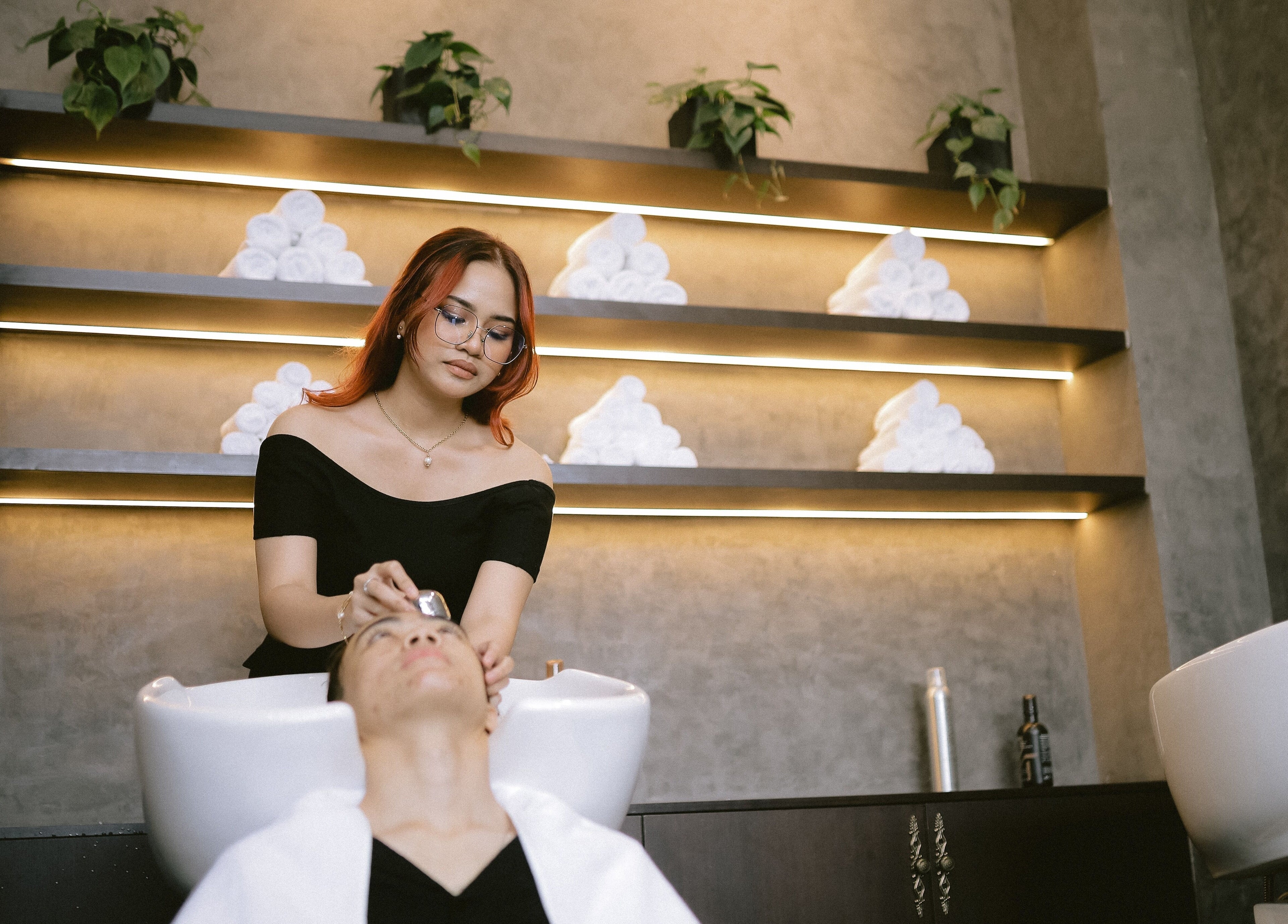 Stylist at BarberBar at Pavilion Embassy, Kuala Lumpur, offering a relaxing head spa treatment.