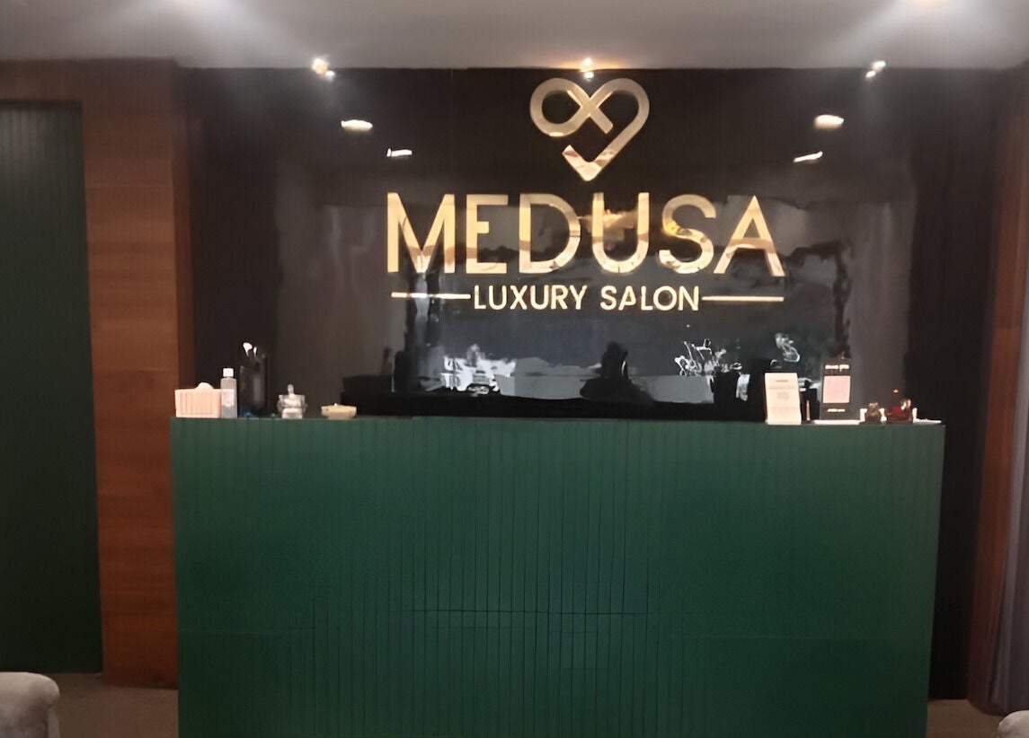 Elegant front desk at Medusa Luxury Spa, Raipur, Chhattisgarh, IN with illuminated logo.