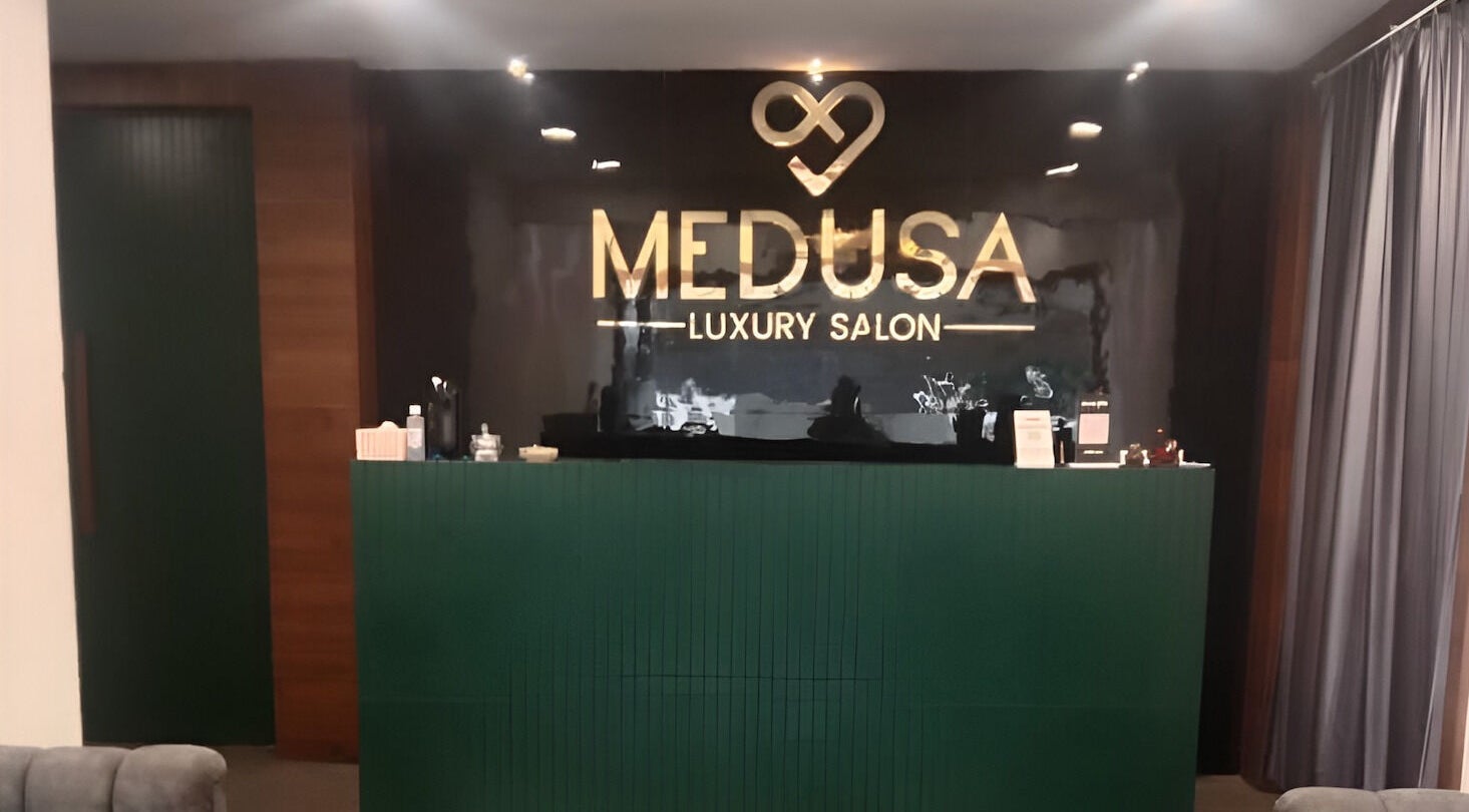 Elegant front desk at Medusa Luxury Spa, Raipur, Chhattisgarh, IN with illuminated logo.