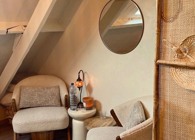 Gezellige hoek bij Noble Nature in Geluveld, Vlaams Gewest, BE met comfortabele zitruimte en sfeerverlichting.