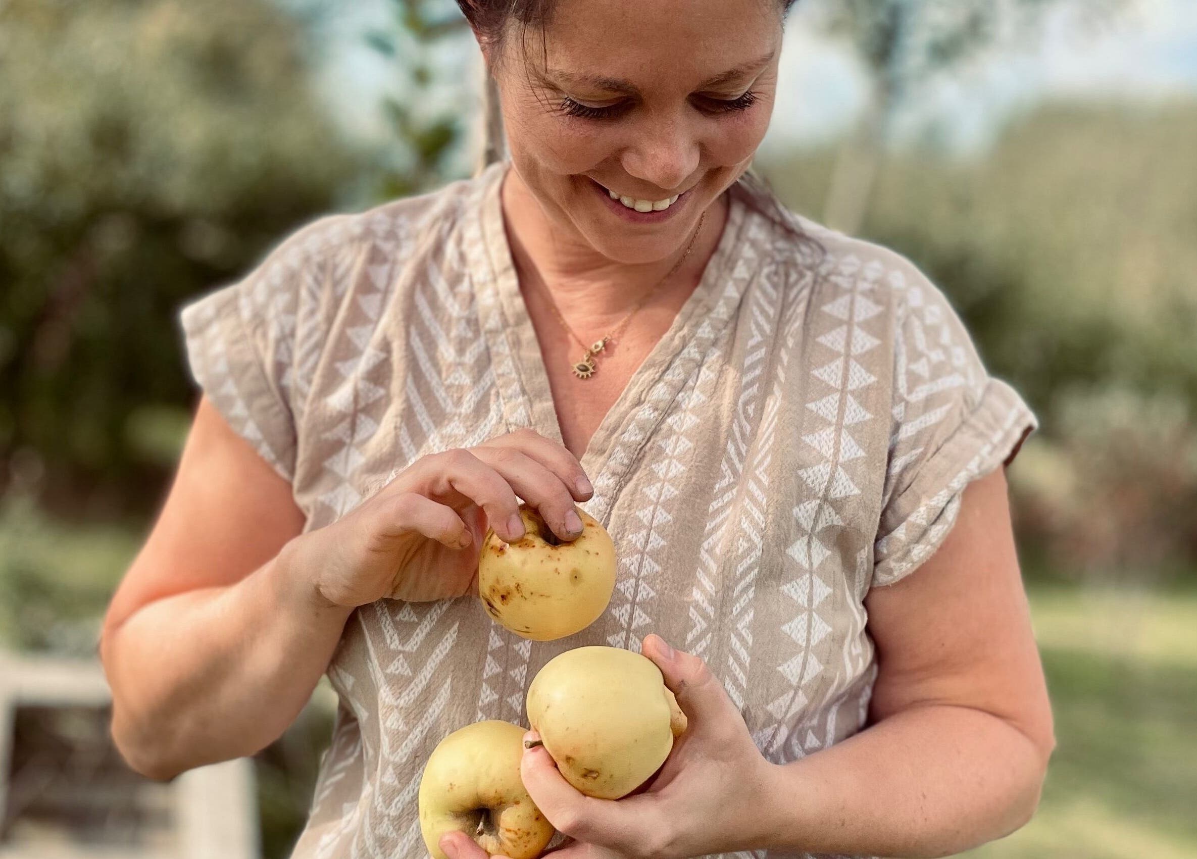 Vrouw met appels in tuin bij Noble Nature, Geluveld, Vlaams Gewest, BE.
