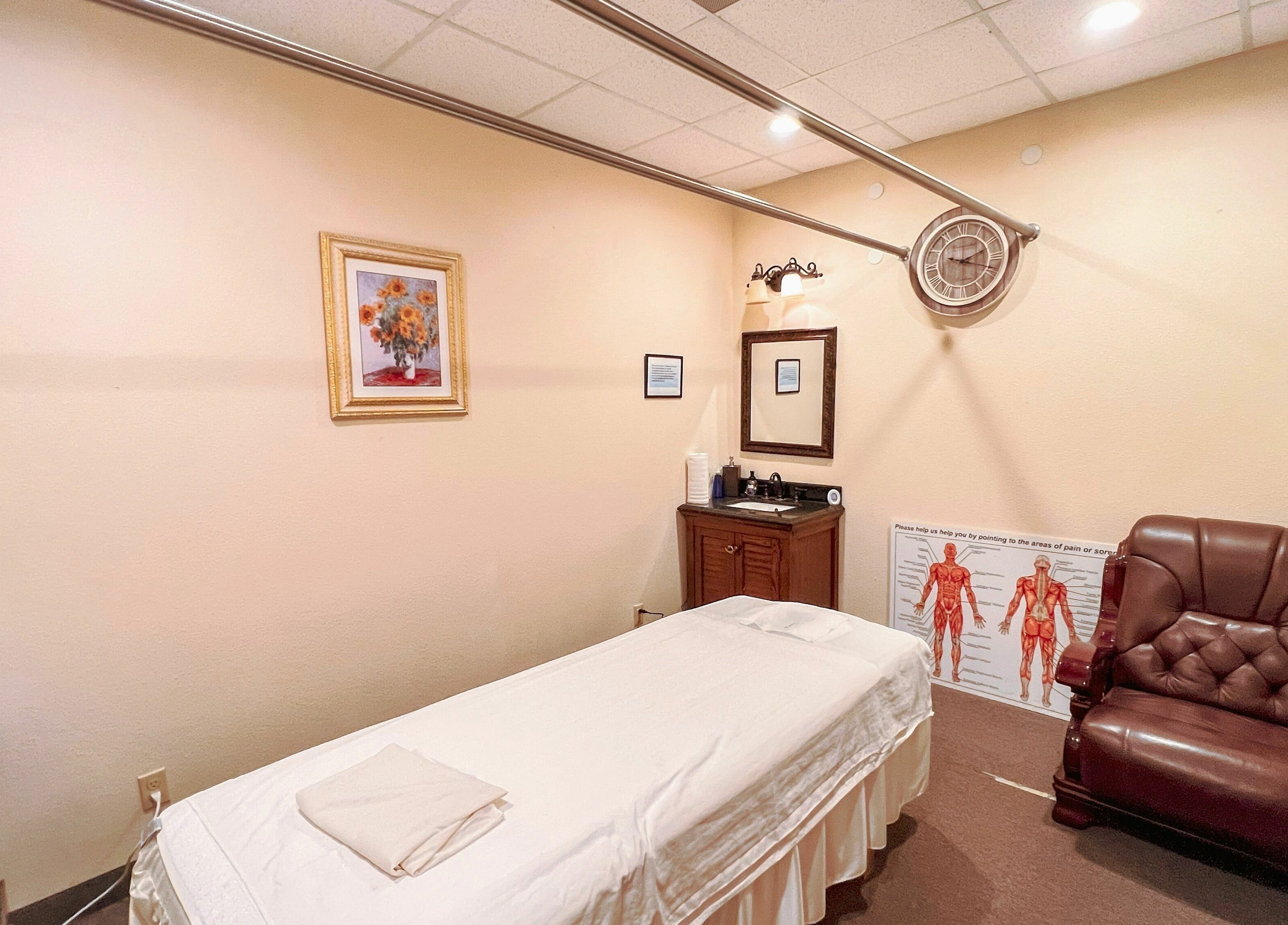 Tranquil massage room at Bluebonnet Massage, featuring a comfy chair and massage bed in Irving, Texas, US.