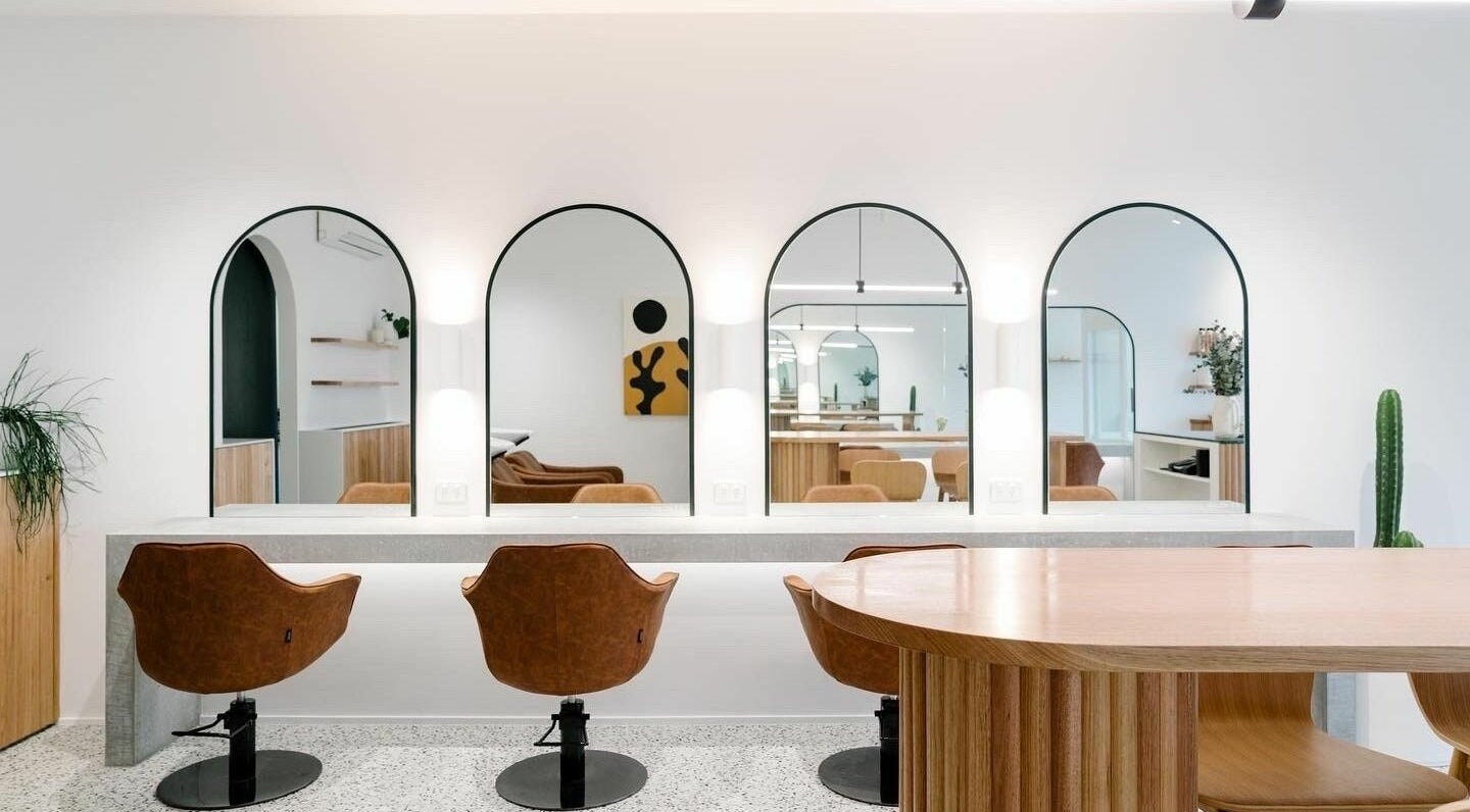Modern salon with arched mirrors at Michaela Thayre, Collaroy, New South Wales, AU showing stylish interior design.