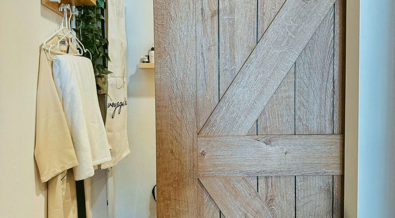 Wooden door and robes at Voyage de Beauty, Singapore, SG creating a cozy, welcoming ambiance.