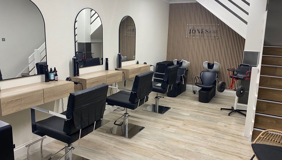 Modern salon interior at Jones & Co, Saint Ives, England, GB, featuring stylish chairs and mirrors.