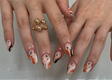 Intricate nail art at BN STUDIO, Coventry, England, GB featuring orange, black, and white swirls.