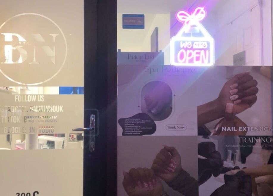 Bn Studio entrance displaying a neon sign and beauty service posters in Coventry, England, GB.