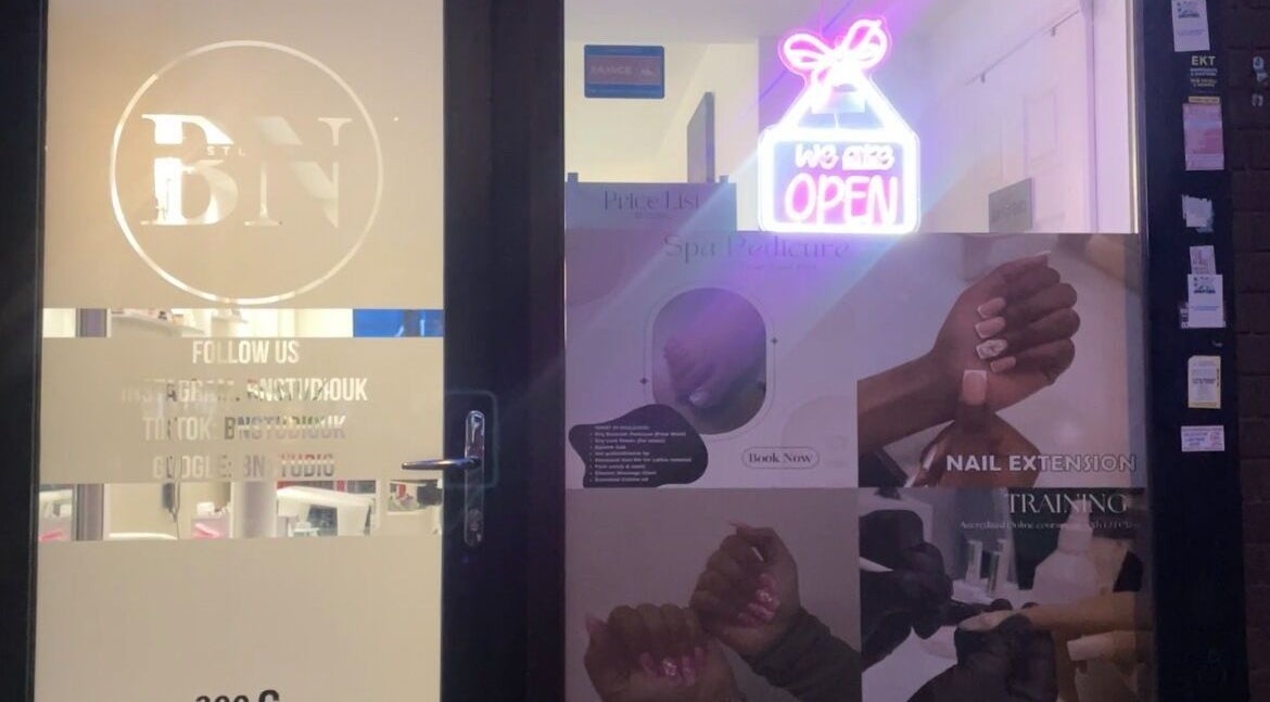 Bn Studio Coventry entrance with glowing open sign and nail service posters.