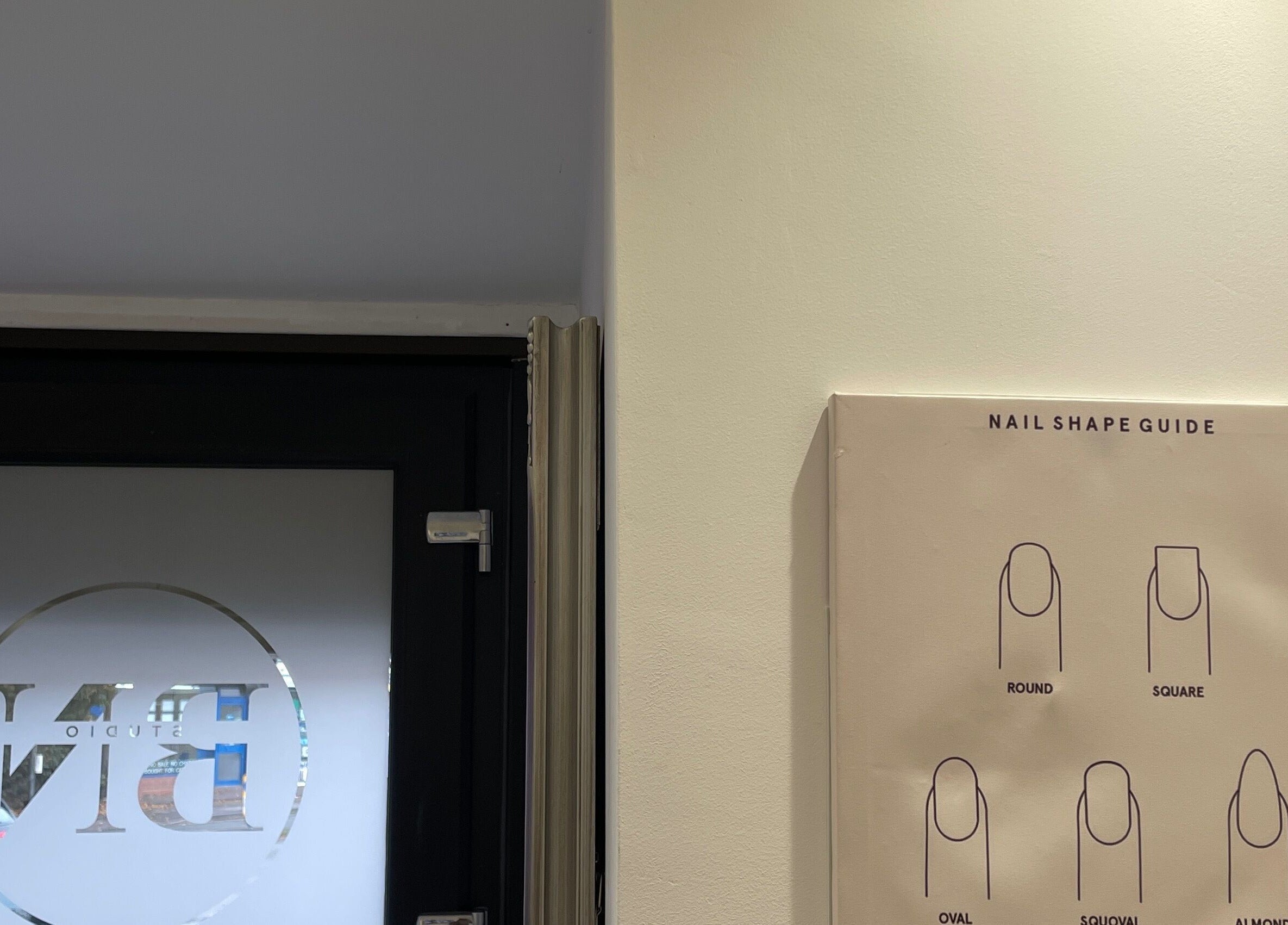 Nail shape guide displayed at Bn Studio, Coventry, England, GB, adjacent to a sleek frosted glass door.