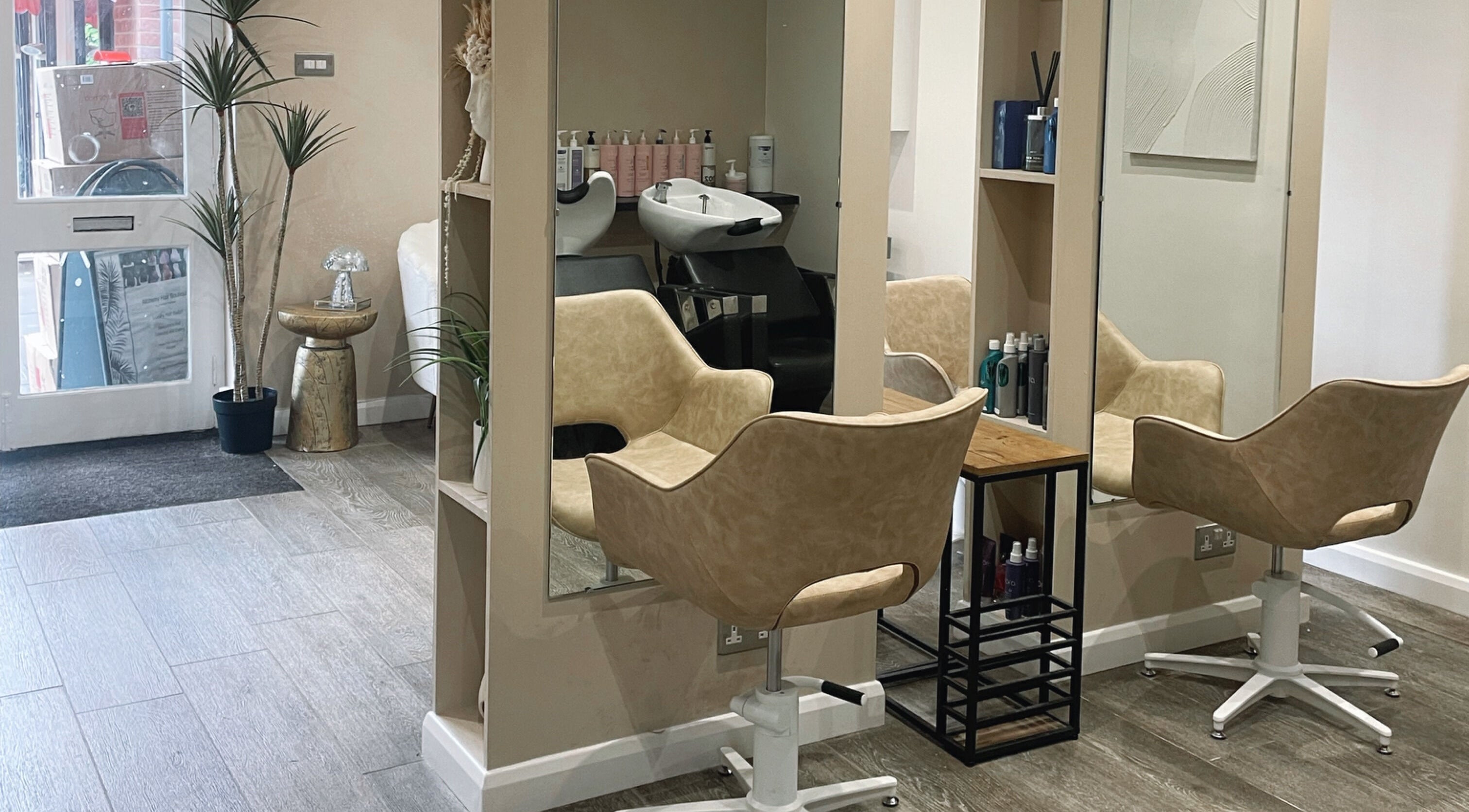 Elegant beauty stations at Alchemy Hair in Caddington, England, GB, highlighting stylish salon chairs and mirrors.