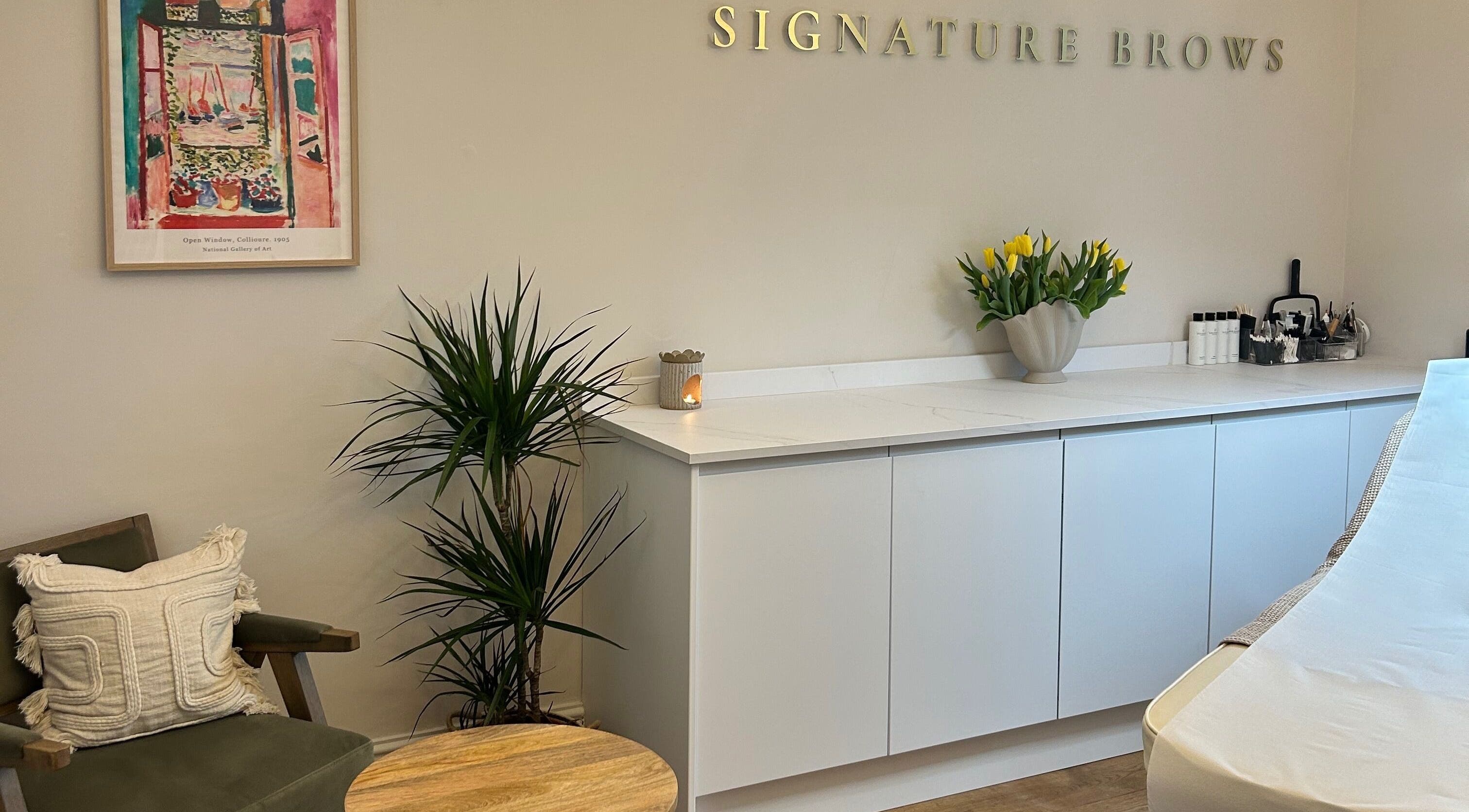 Bright, welcoming interior of Signature Brows in Bridgend, Wales, GB with stylish decor including plants and art.