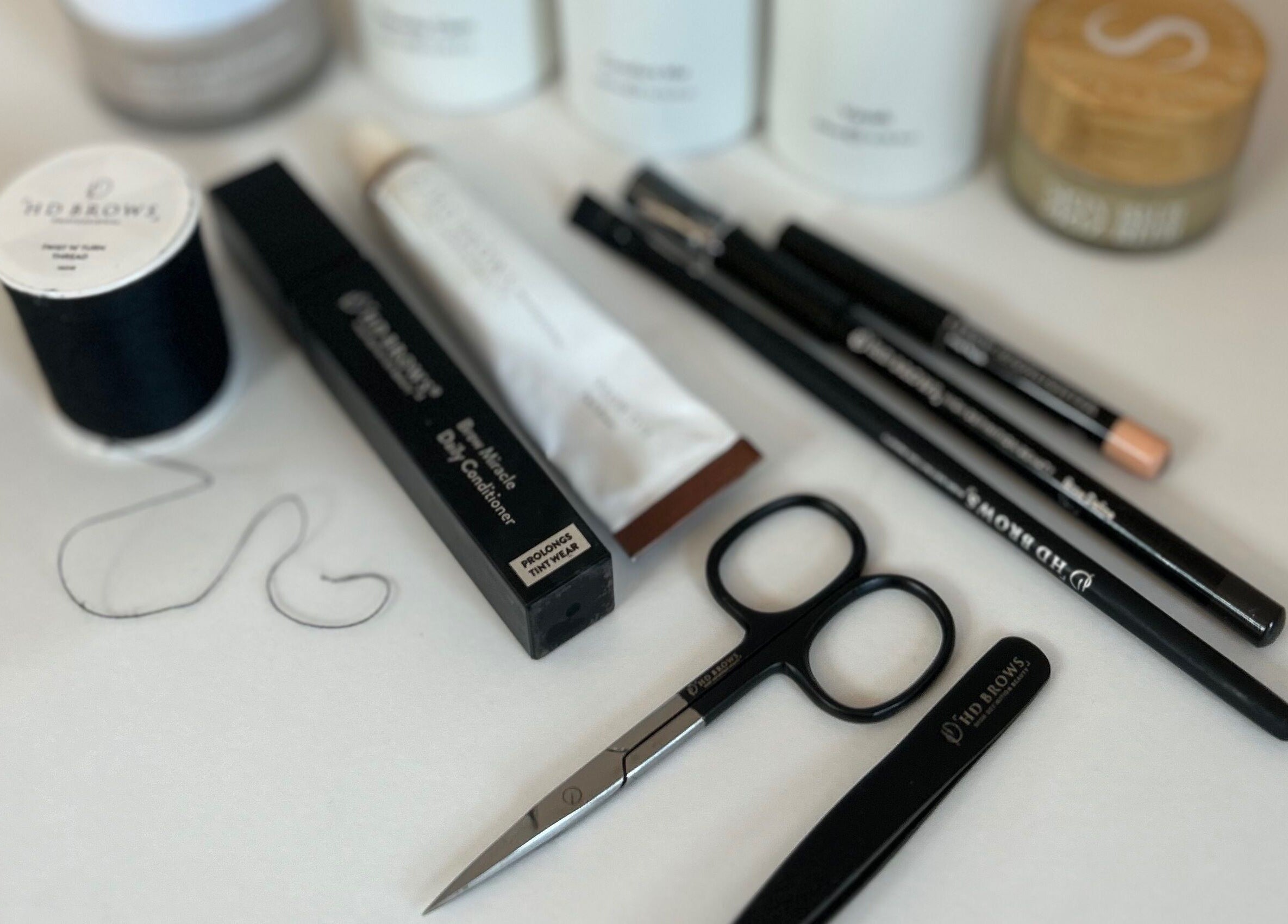 Signature Brows beauty tools and products on display in Bridgend, Wales, GB; scissors and pencils included.