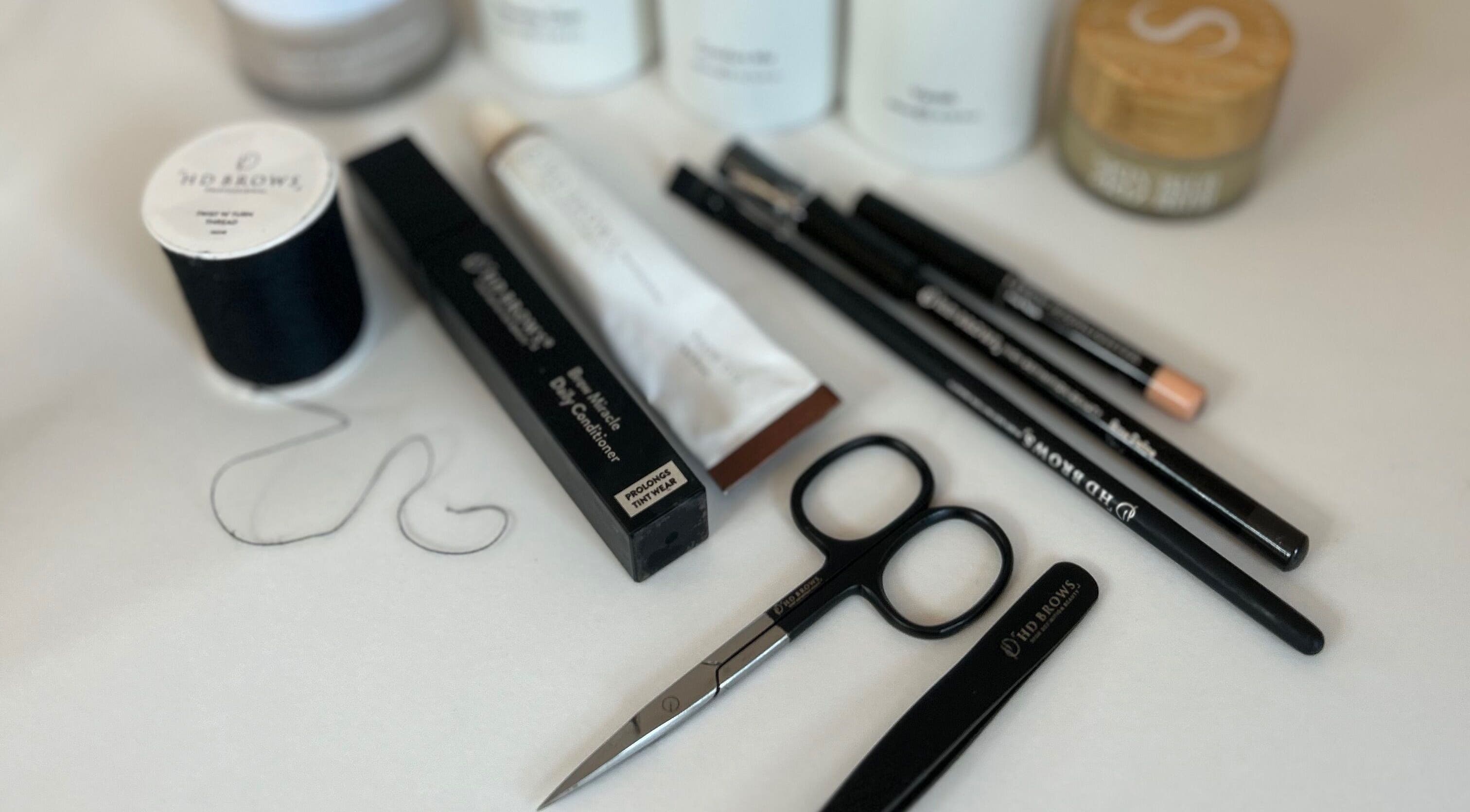 Signature Brows beauty tools and products on display in Bridgend, Wales, GB; scissors and pencils included.