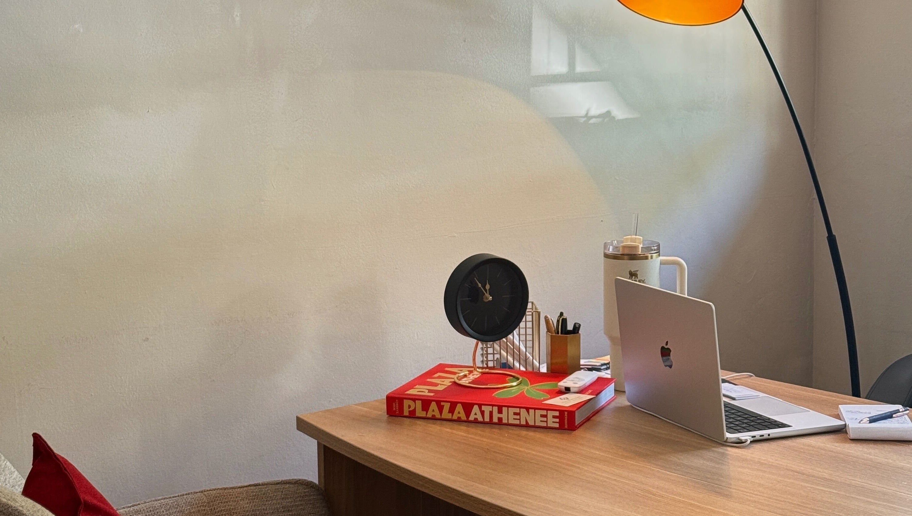 Cozy, elegant desk setup at Mii Health, Johannesburg, Gauteng, ZA, with a lamp, clock, and laptop.