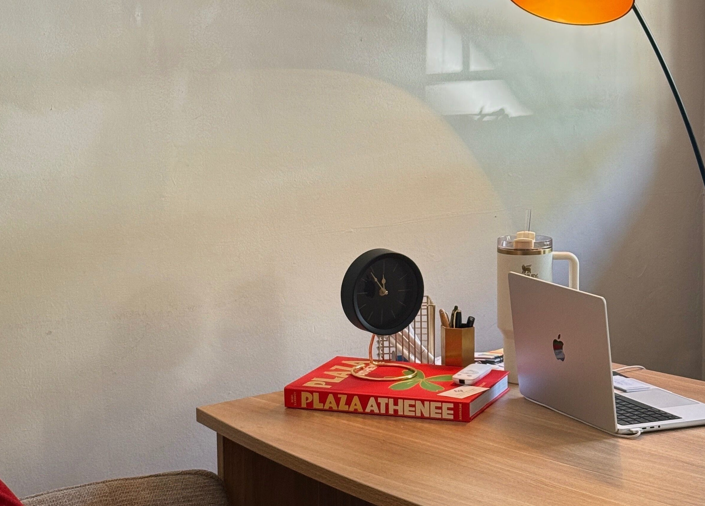Cozy, elegant desk setup at Mii Health, Johannesburg, Gauteng, ZA, with a lamp, clock, and laptop.