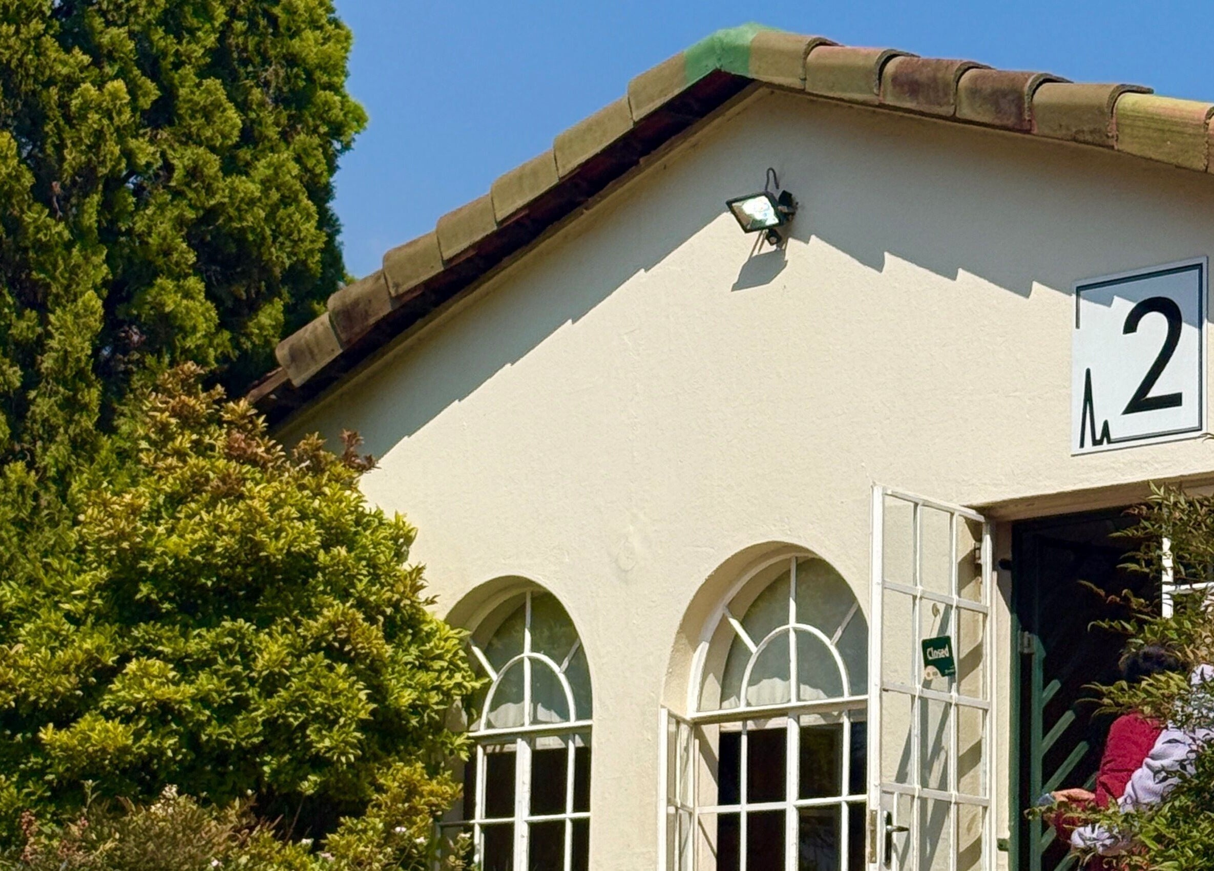 Mii Health exterior with arched windows in Johannesburg, Gauteng, ZA. Lush greenery surrounds the serene venue.