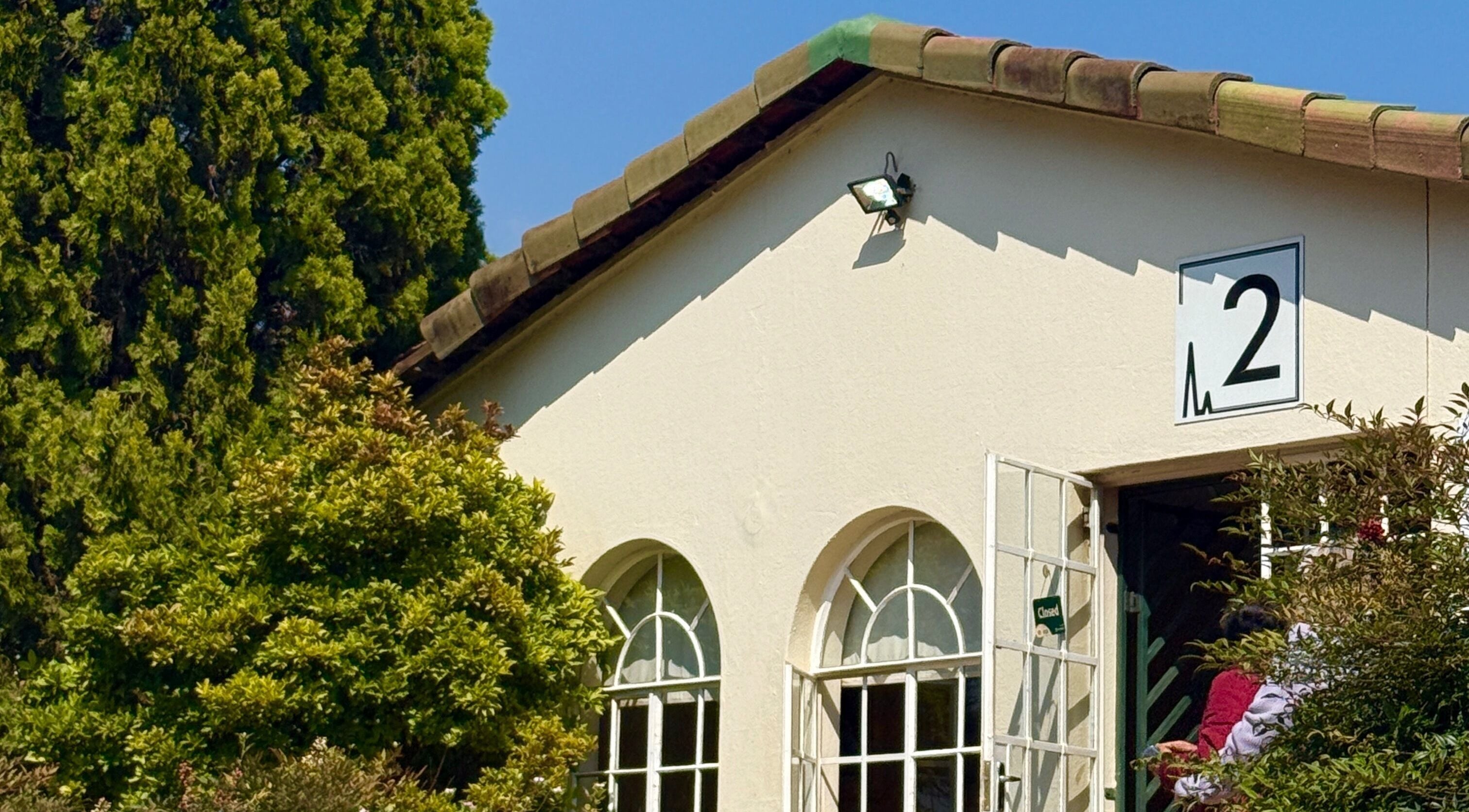 Mii Health exterior with arched windows in Johannesburg, Gauteng, ZA. Lush greenery surrounds the serene venue.