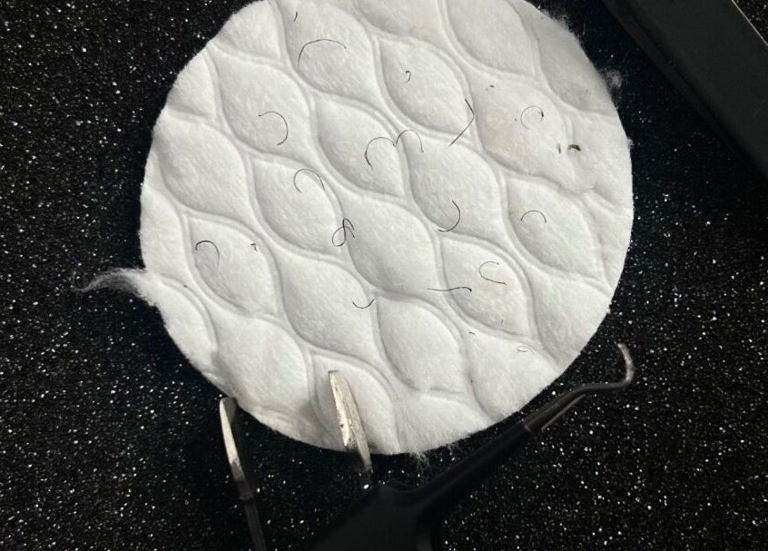 Precision tweezers and a cotton pad with hairs at The Sugar and Skin Lab, Oistins, Christ Church, BB.