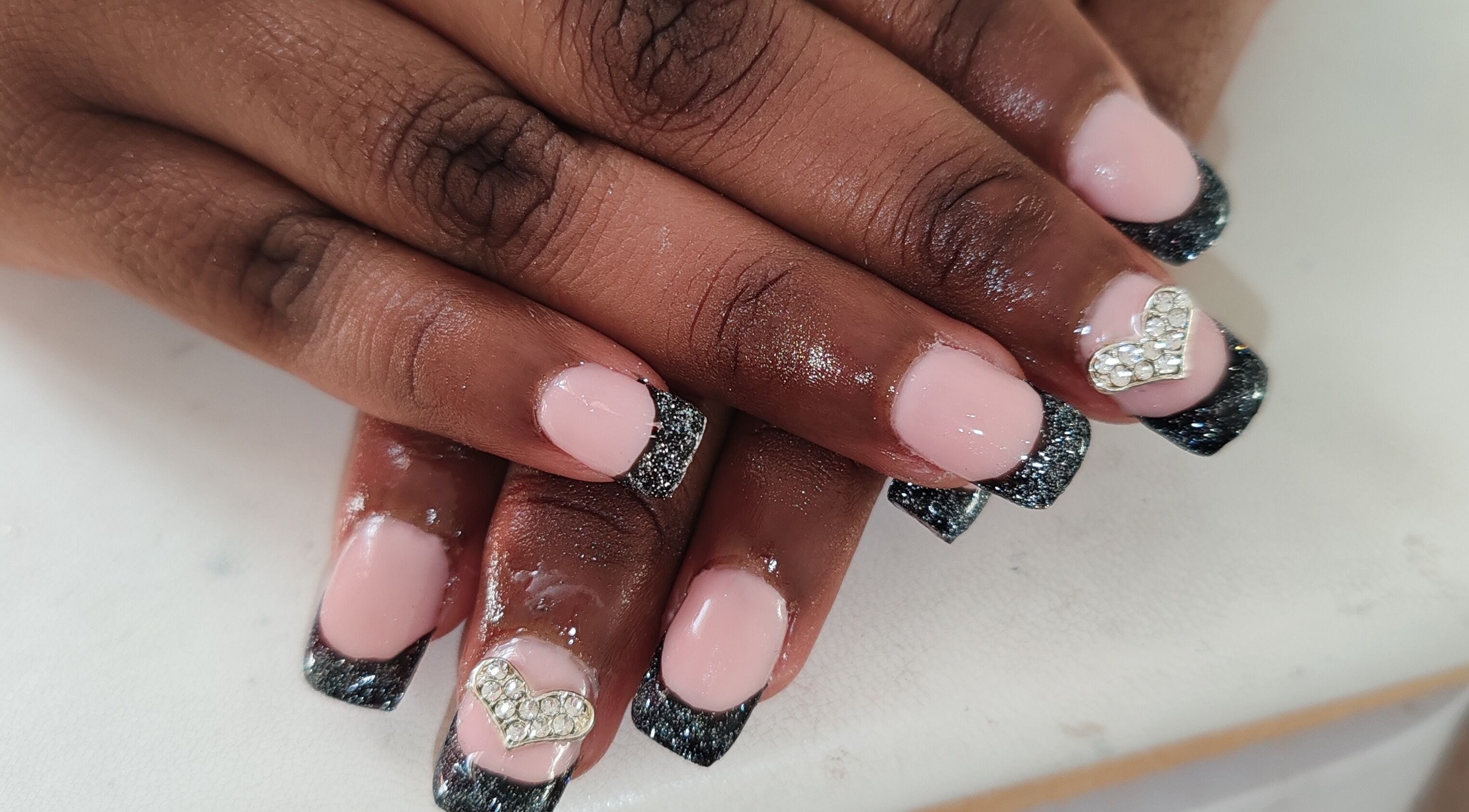 Stylish pink nails with glitter tips and rhinestone heart at Allure Beauty by Wianda, Gqeberha, Eastern Cape, ZA.