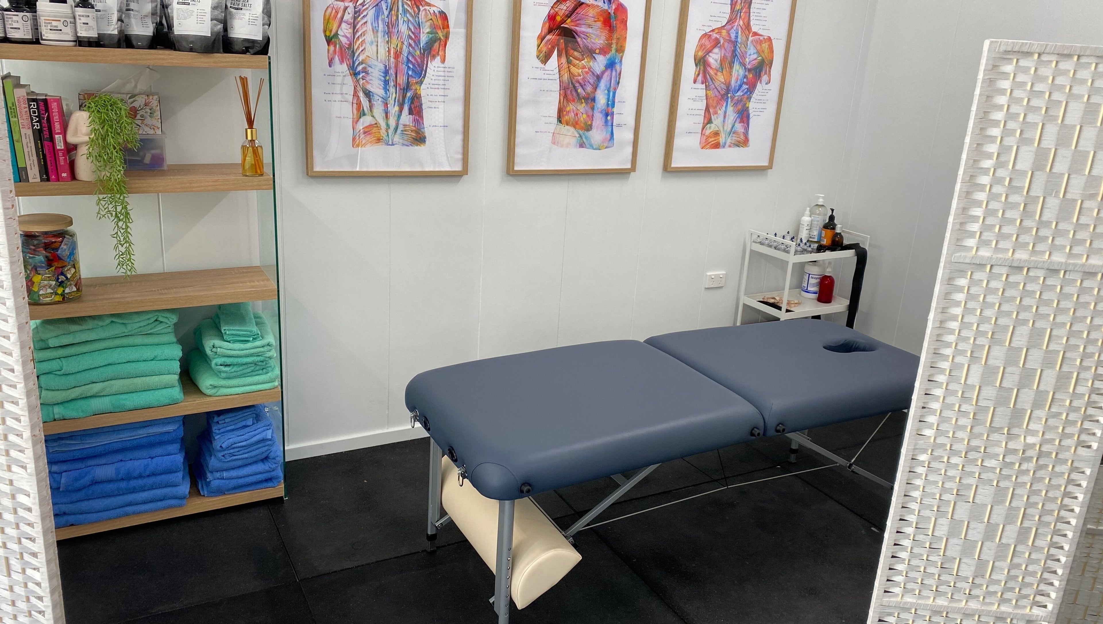Massage room at Proform Coaching and Massage, Singleton, New South Wales, AU with a table and vibrant anatomical art.